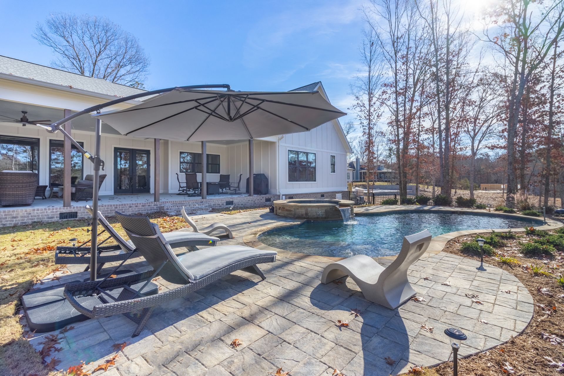 there is a large swimming pool in the backyard of a house .