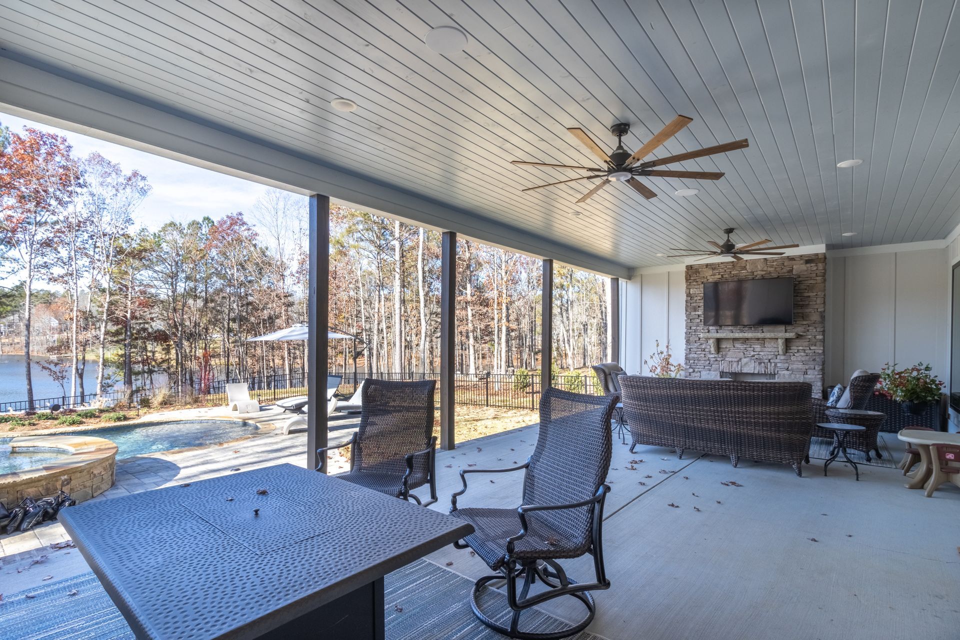 a large covered patio with a table and chairs and a ceiling fan .