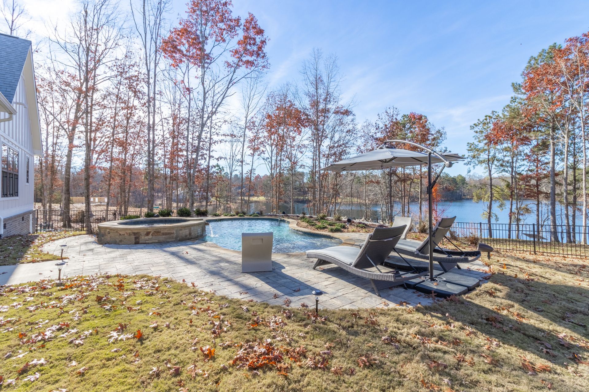 there is a large swimming pool in the backyard of a house .