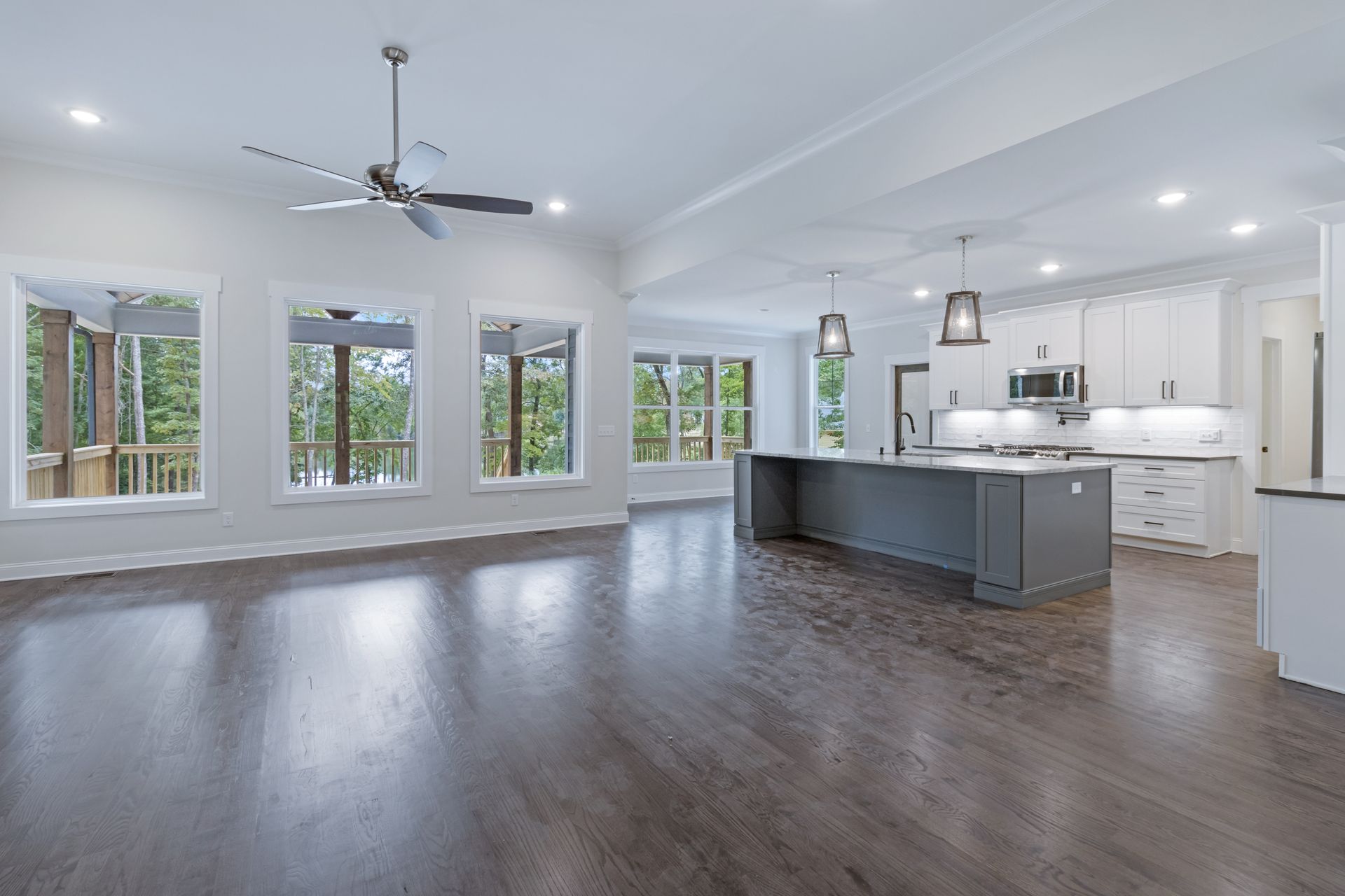 a large empty room with hardwood floors and a ceiling fan .