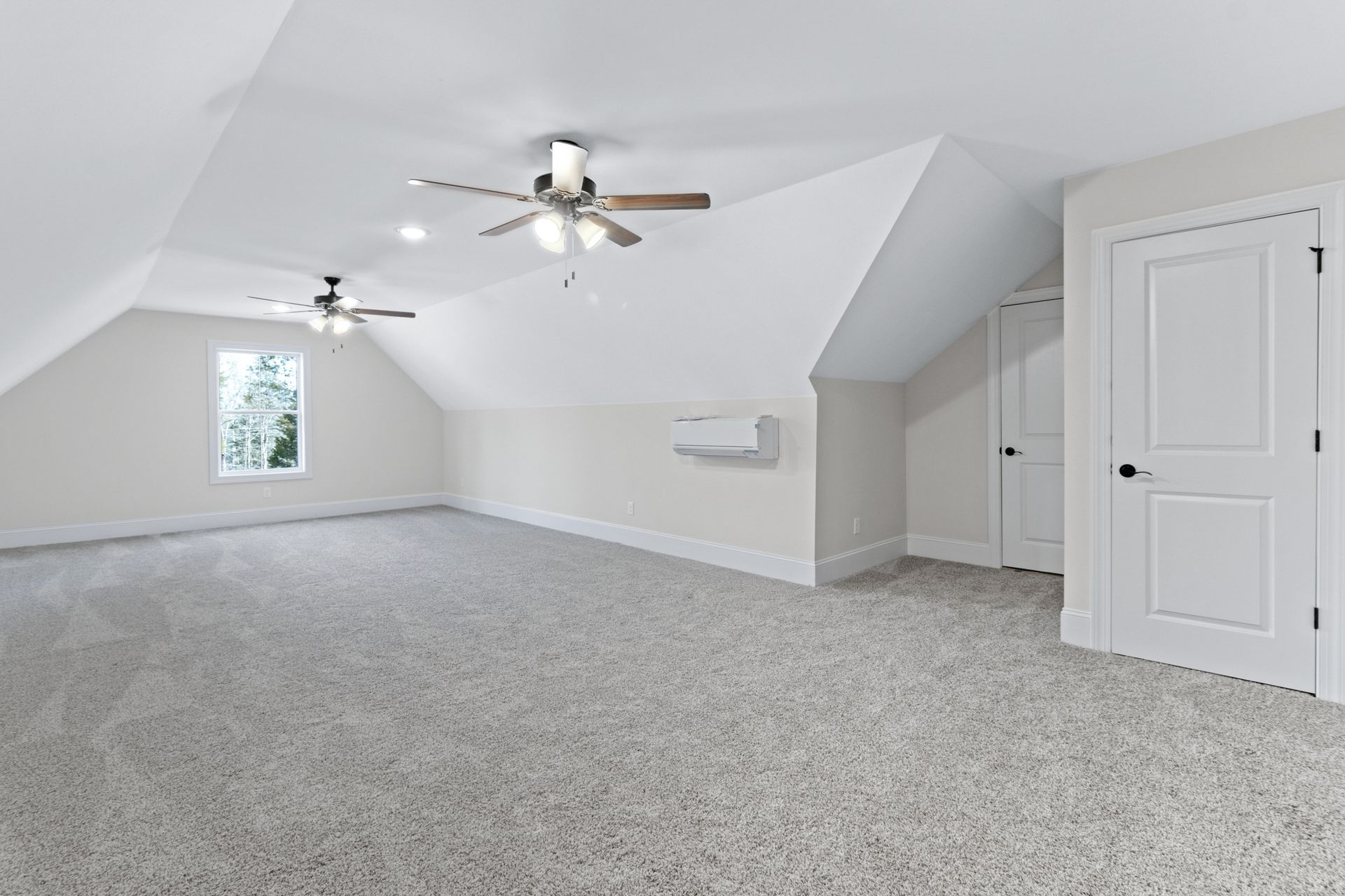 an empty room with a ceiling fan and a window .