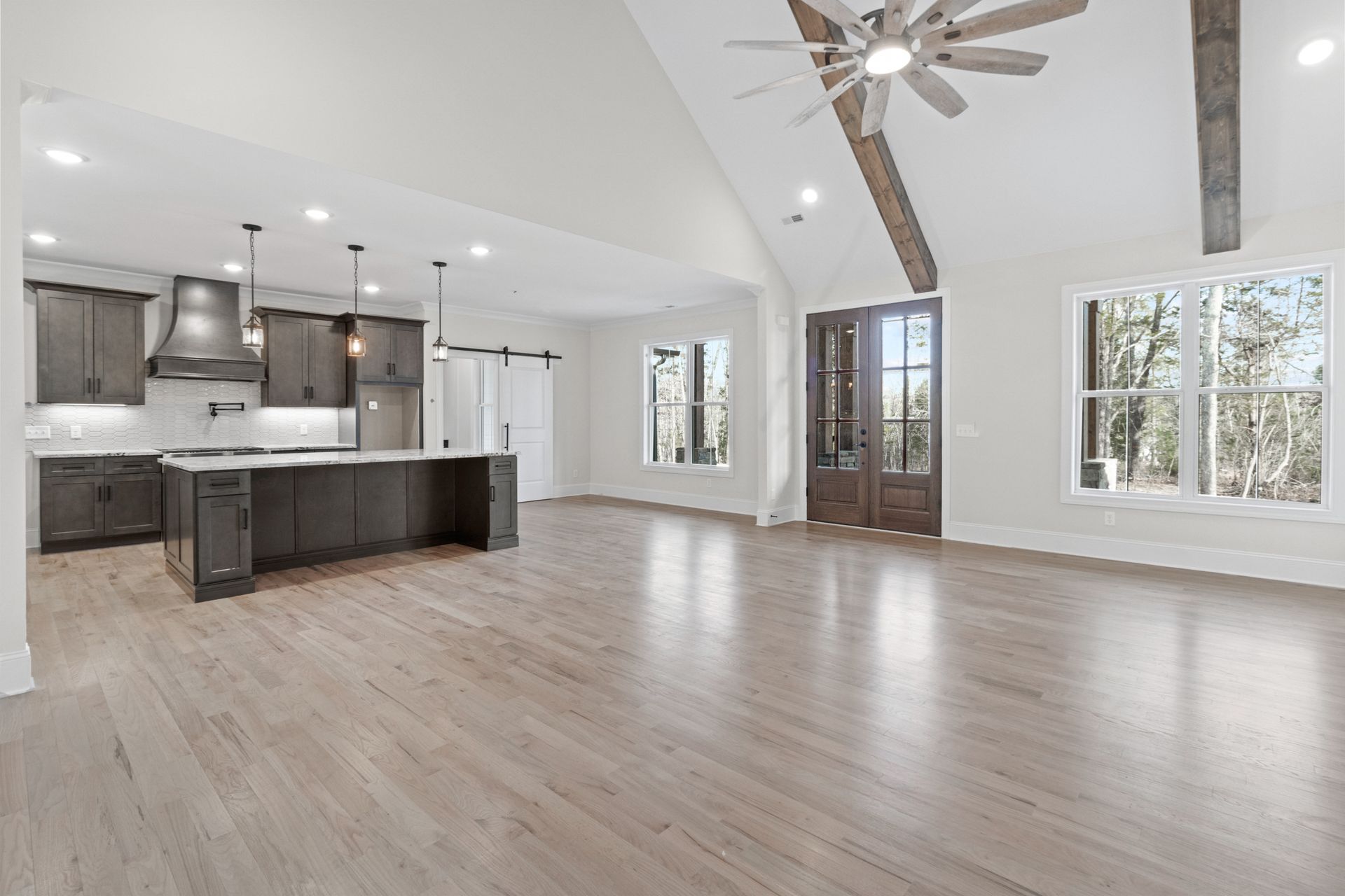 a large empty room with hardwood floors and a ceiling fan .