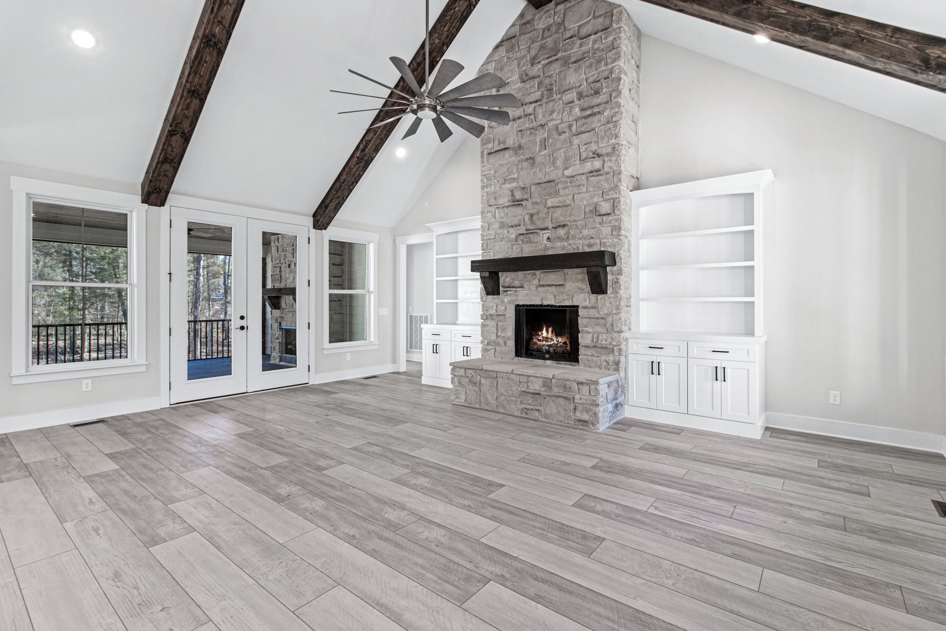 A living room with a fireplace and a ceiling fan.