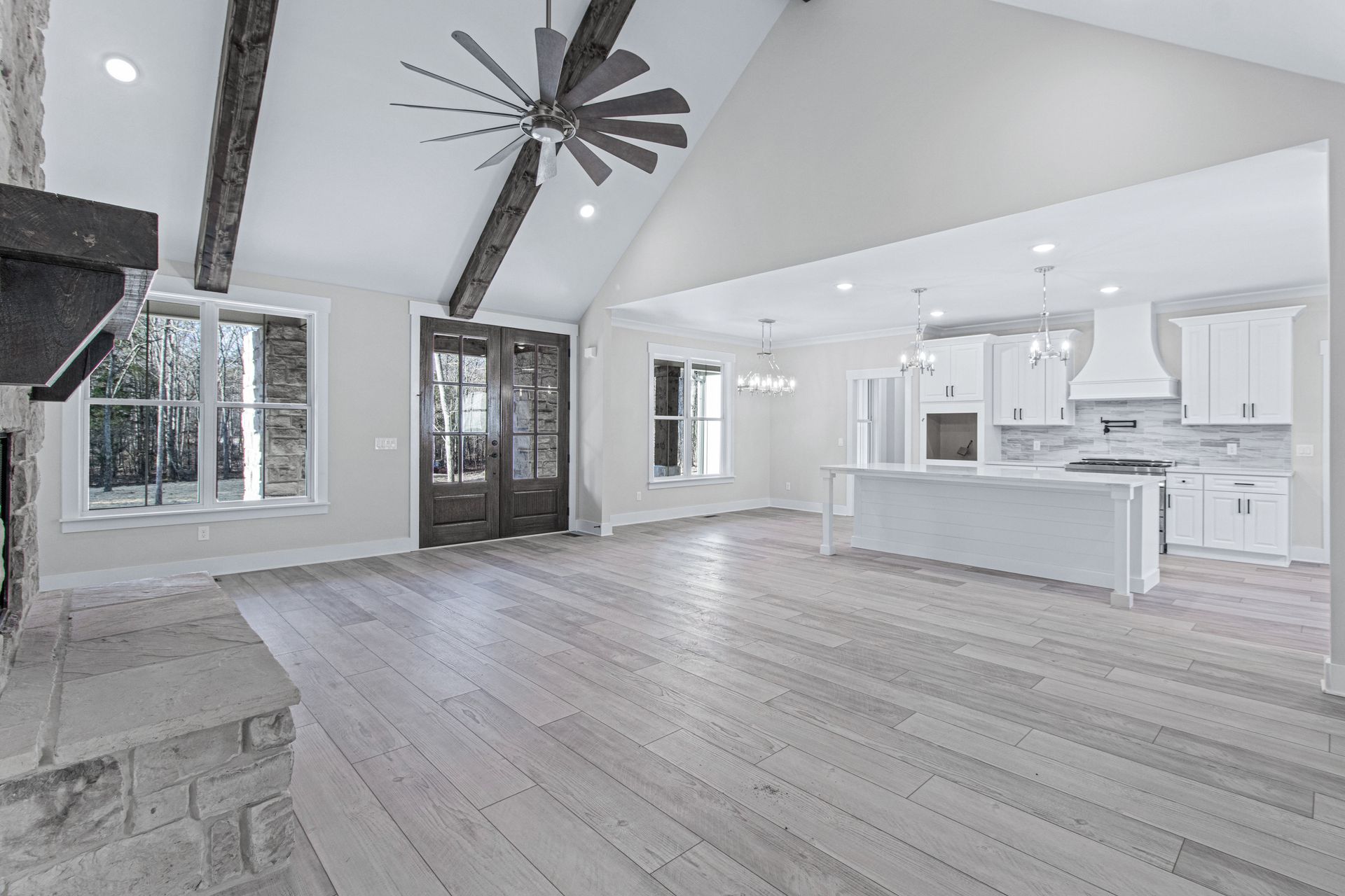 an empty living room with hardwood floors and a ceiling fan .
