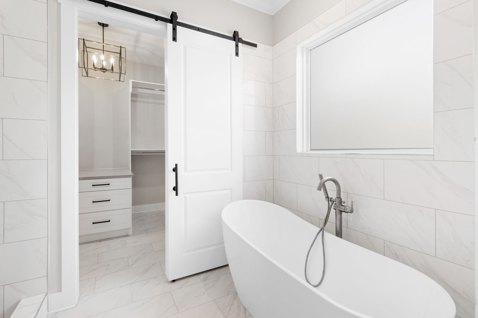 a bathroom with a bathtub and a sliding barn door .