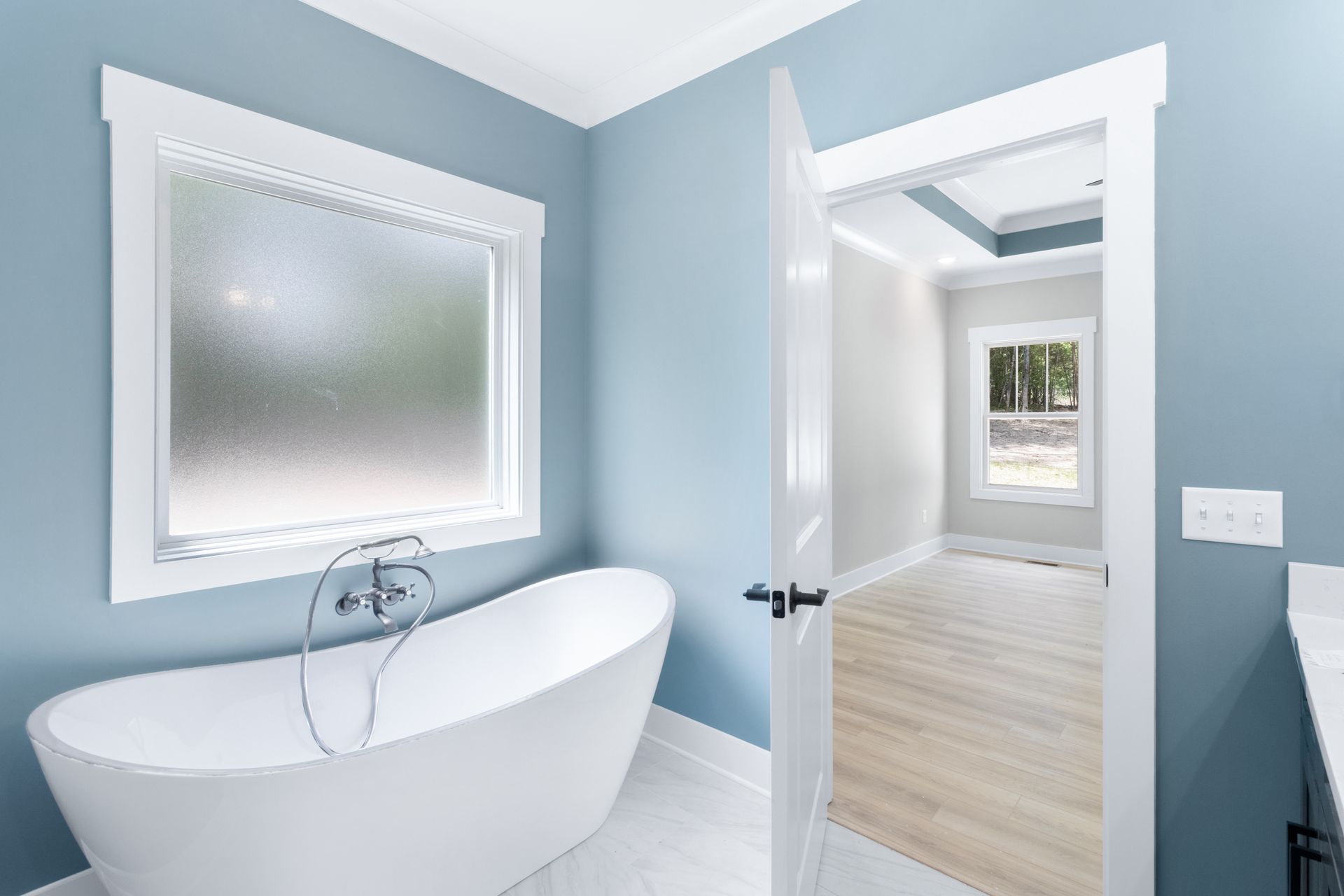 A bathroom with a bathtub and a window.