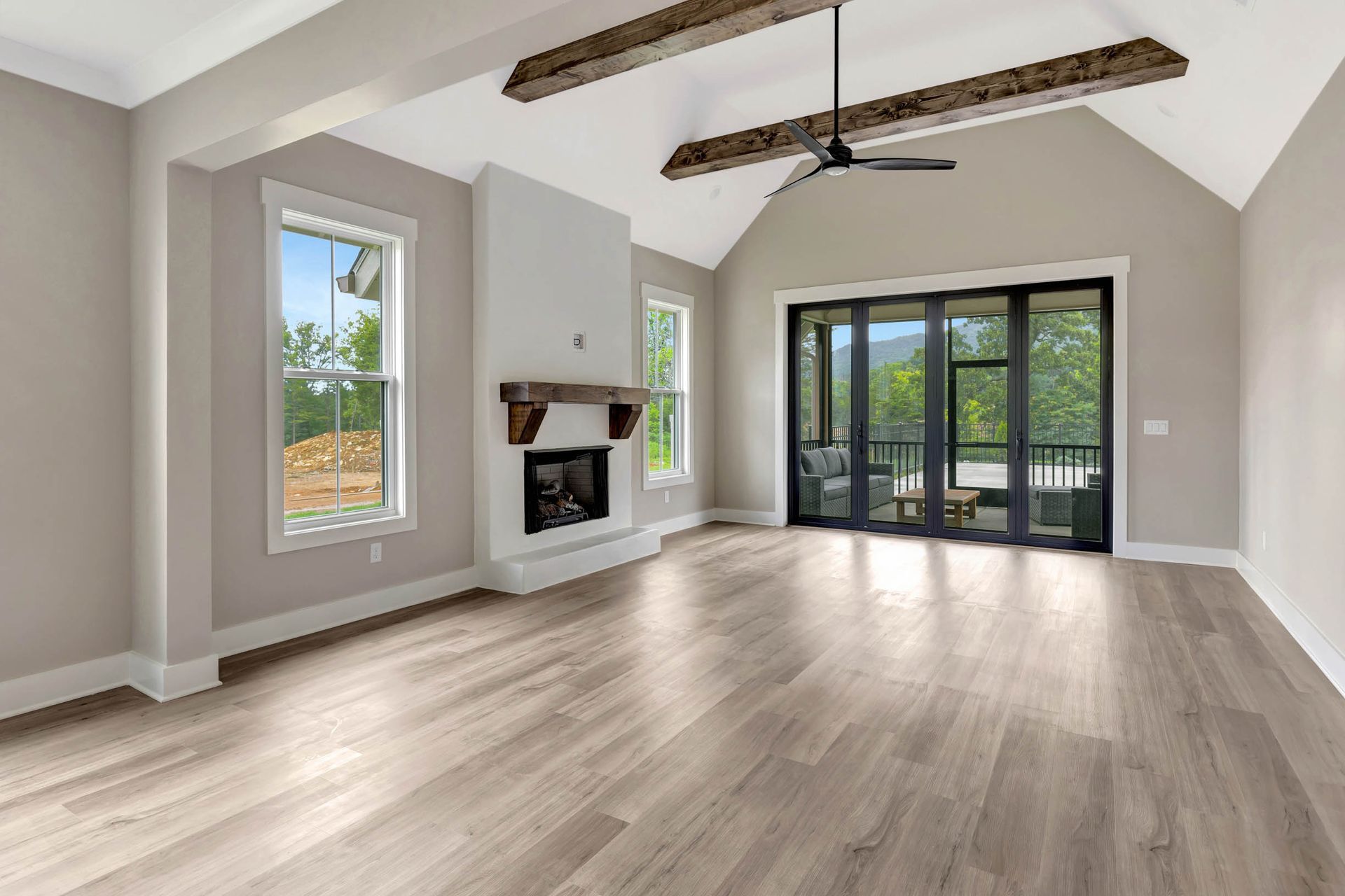 An empty living room with hardwood floors and a fireplace.