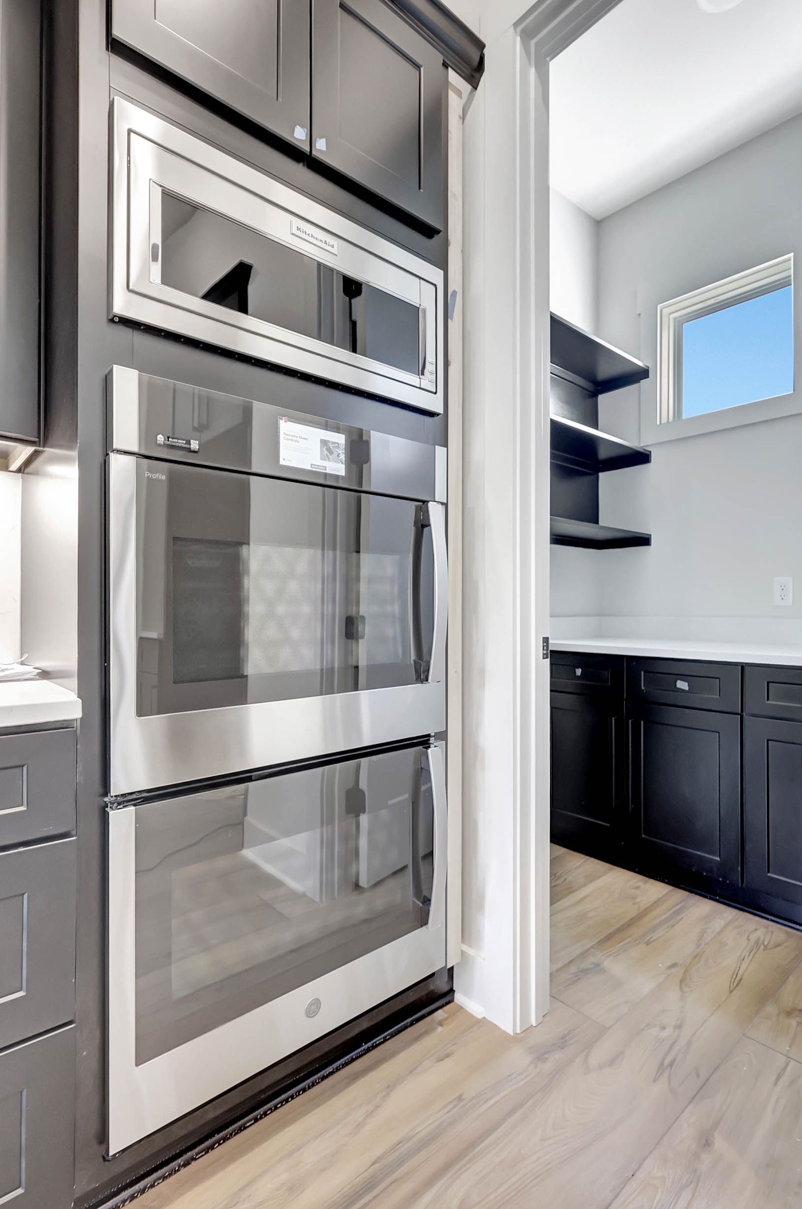A kitchen with stainless steel appliances and black cabinets.