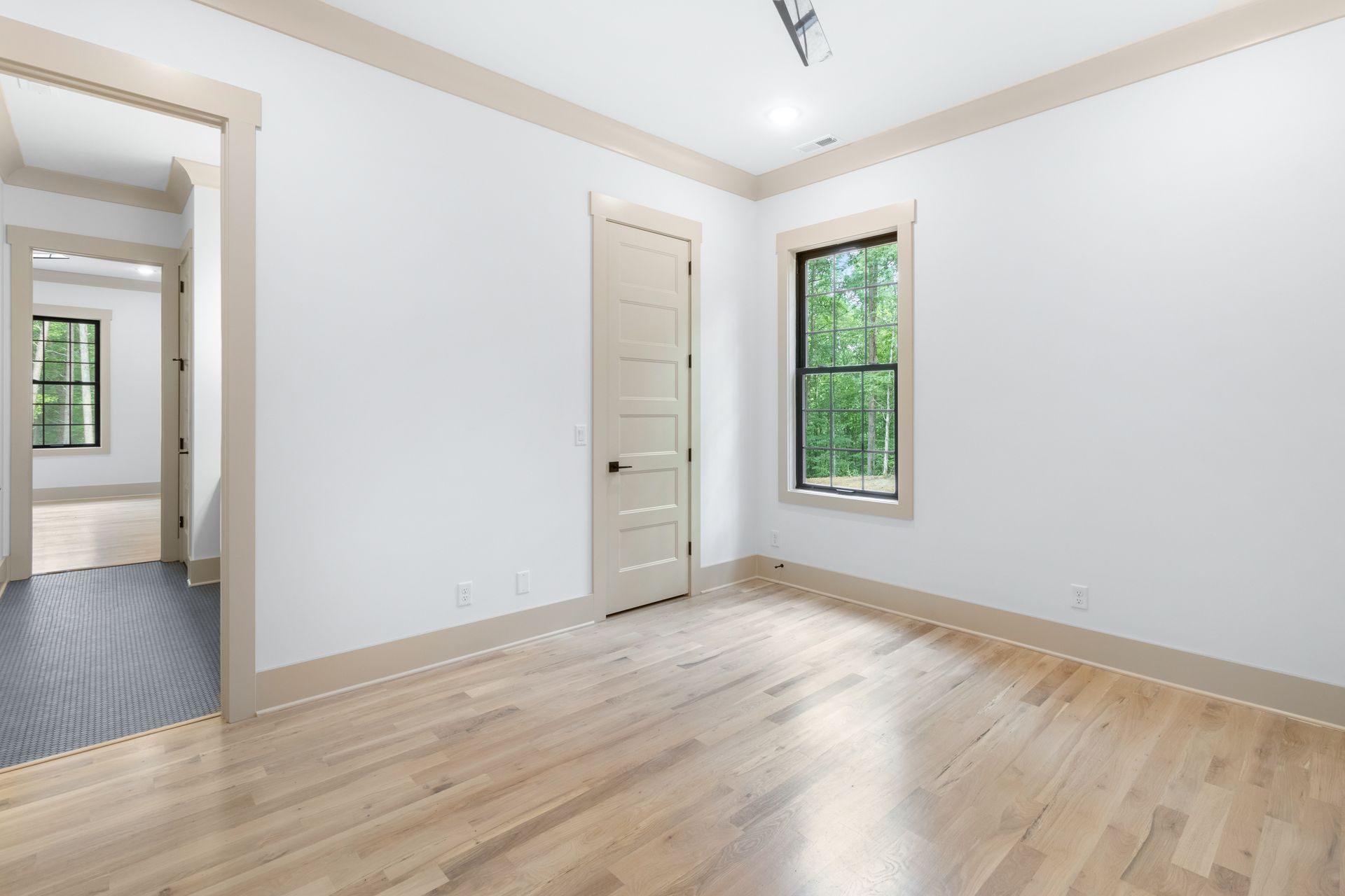 an empty room with hardwood floors and white walls .