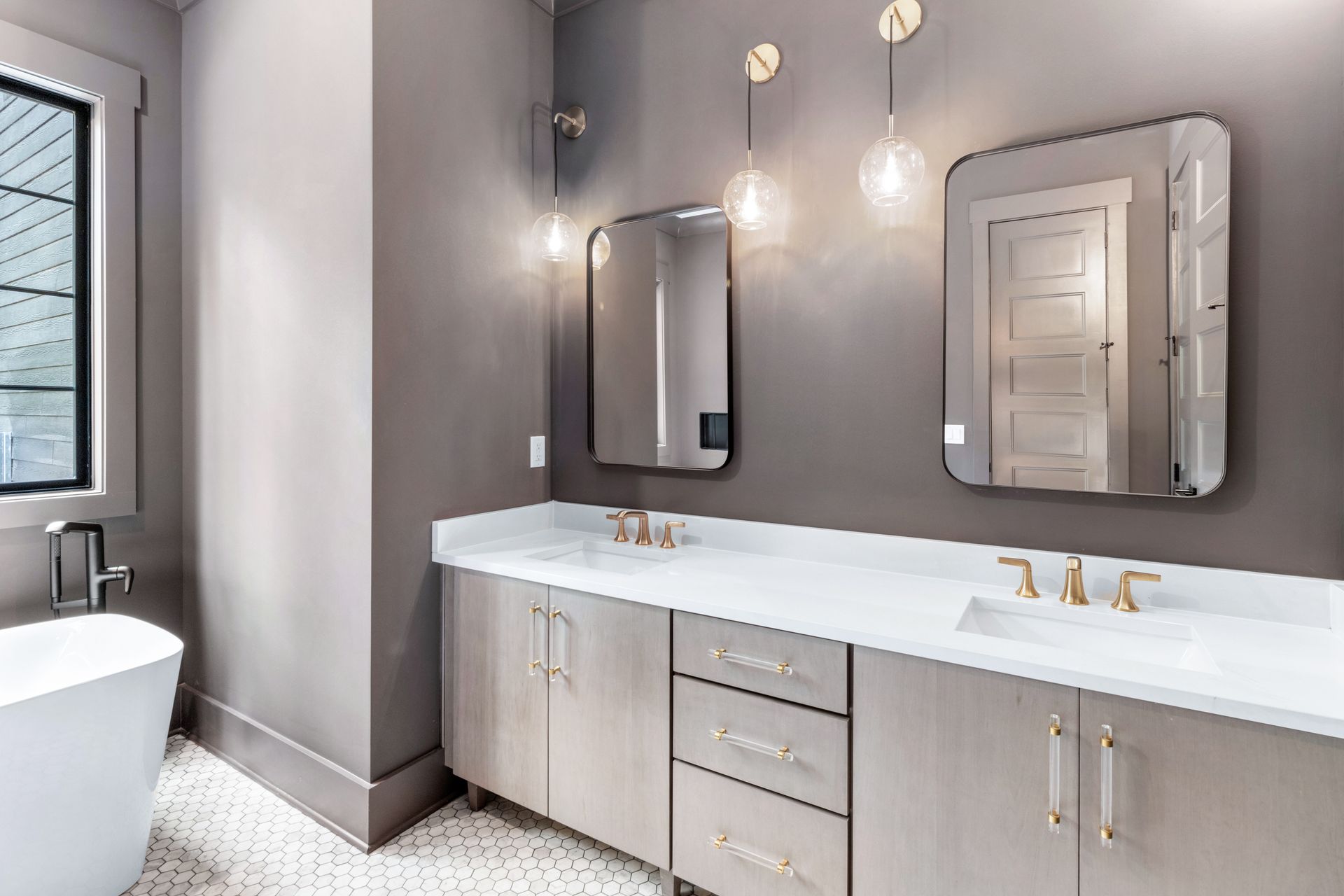 a bathroom with two sinks , two mirrors and a tub .