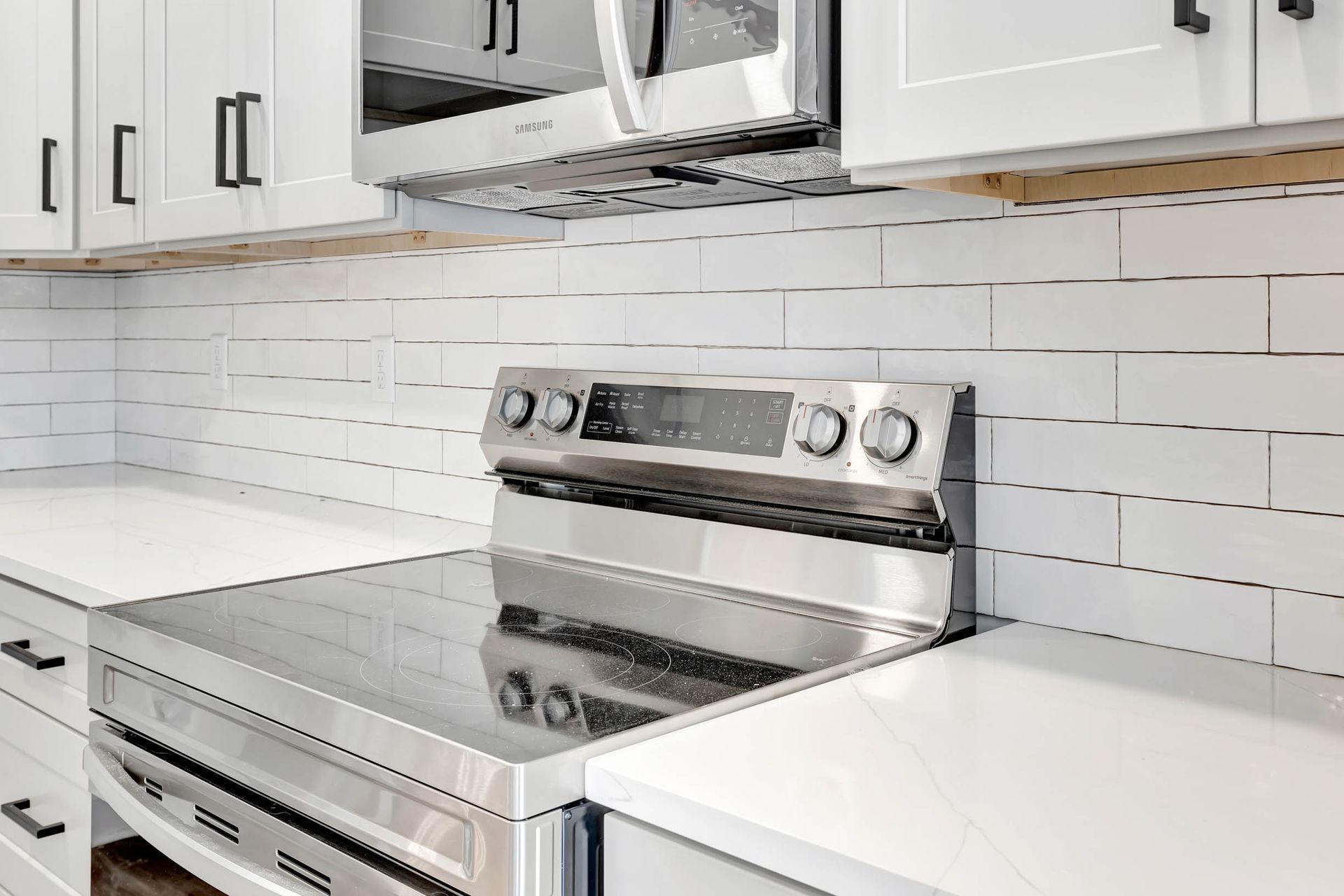 A kitchen with stainless steel appliances and white cabinets.
