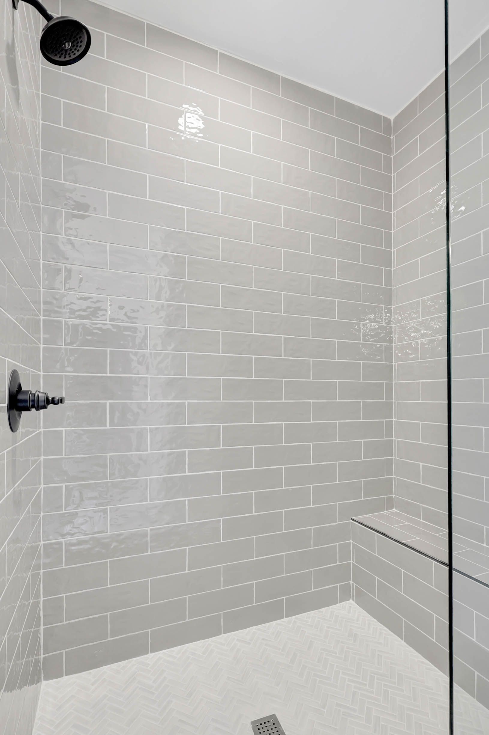 There is a shower with a glass door and a shower head.