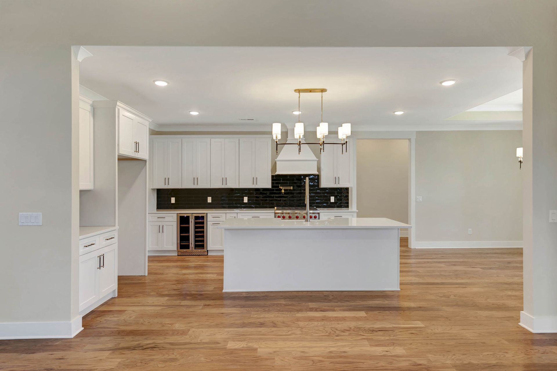 An empty kitchen with a large island in the middle of the room.