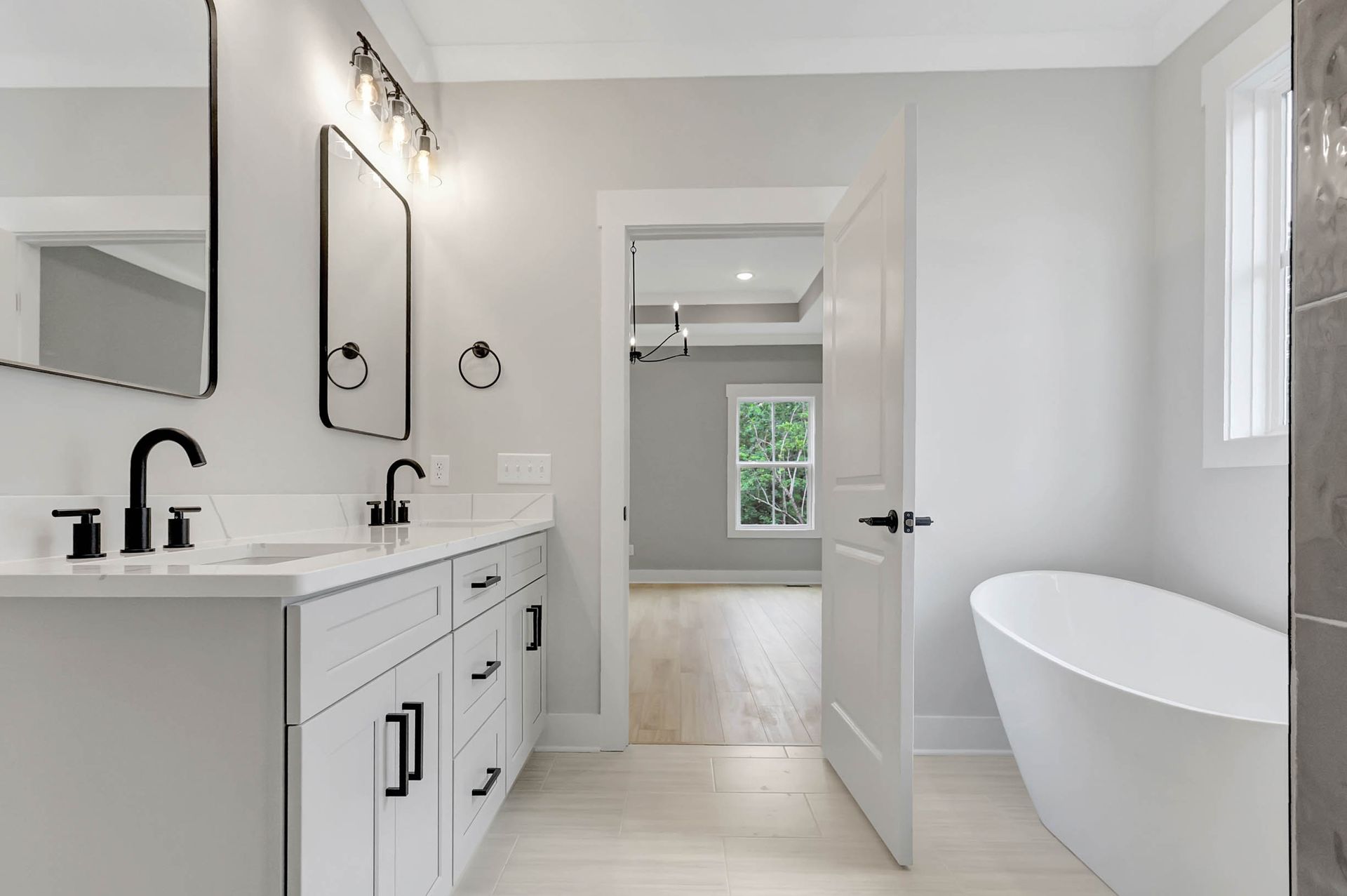 A bathroom with a tub , sink and mirror.