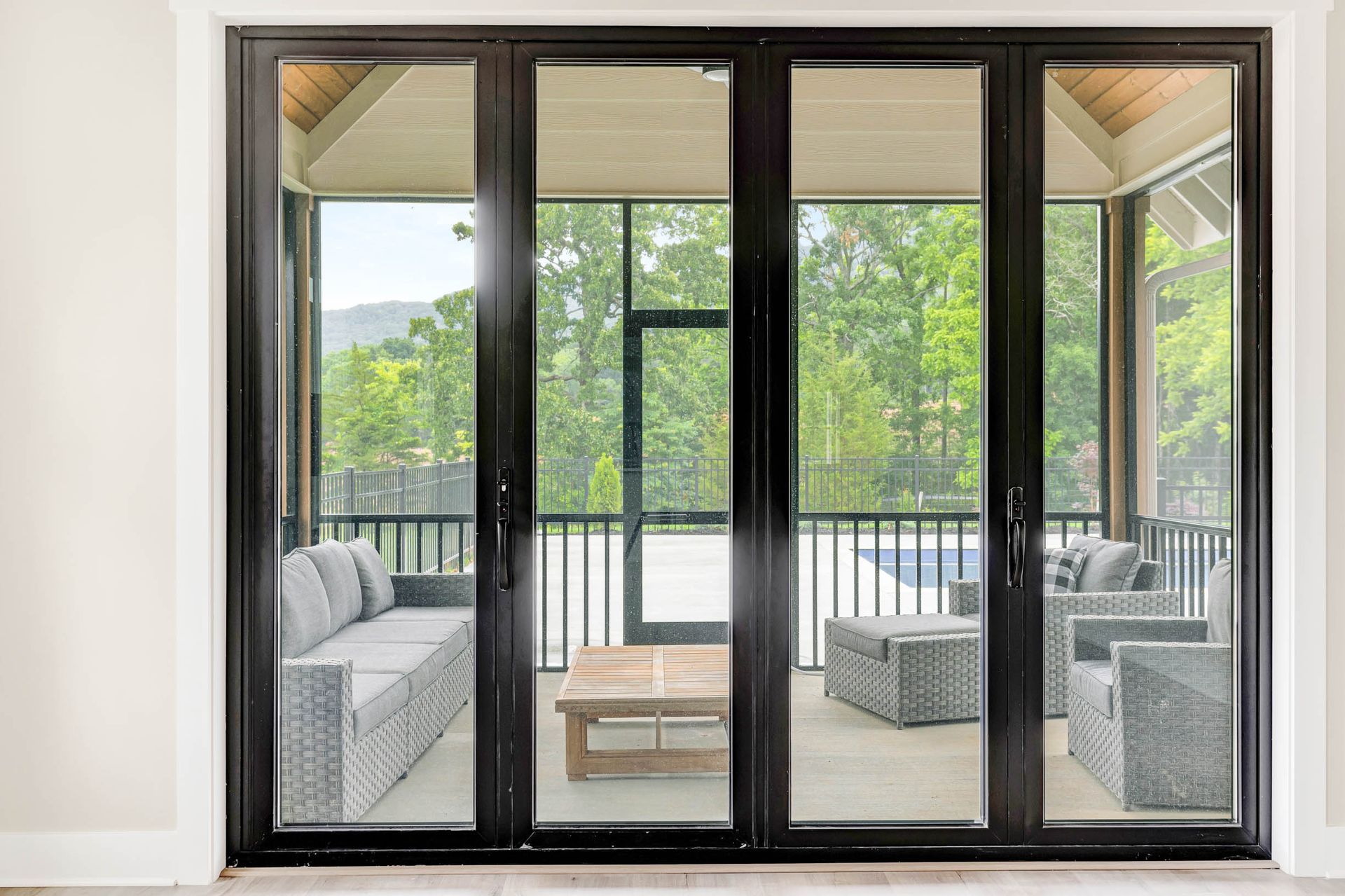 A screened in porch with sliding glass doors leading to a patio.