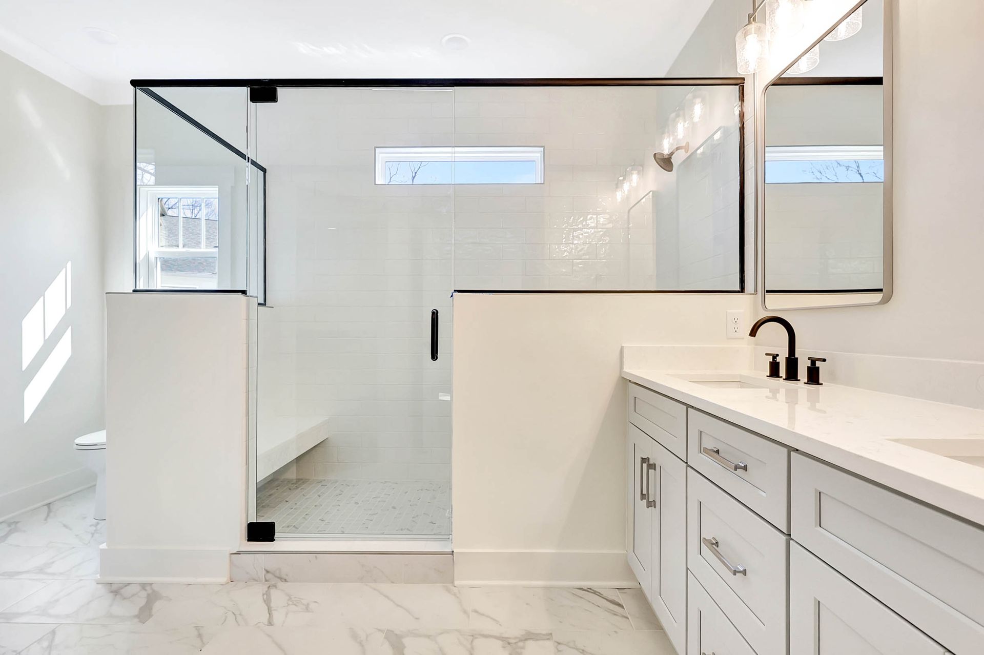A bathroom with a walk in shower , sink and mirror.