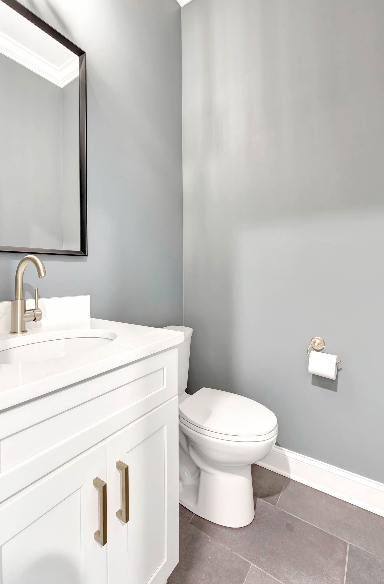 A bathroom with a toilet , sink and mirror.