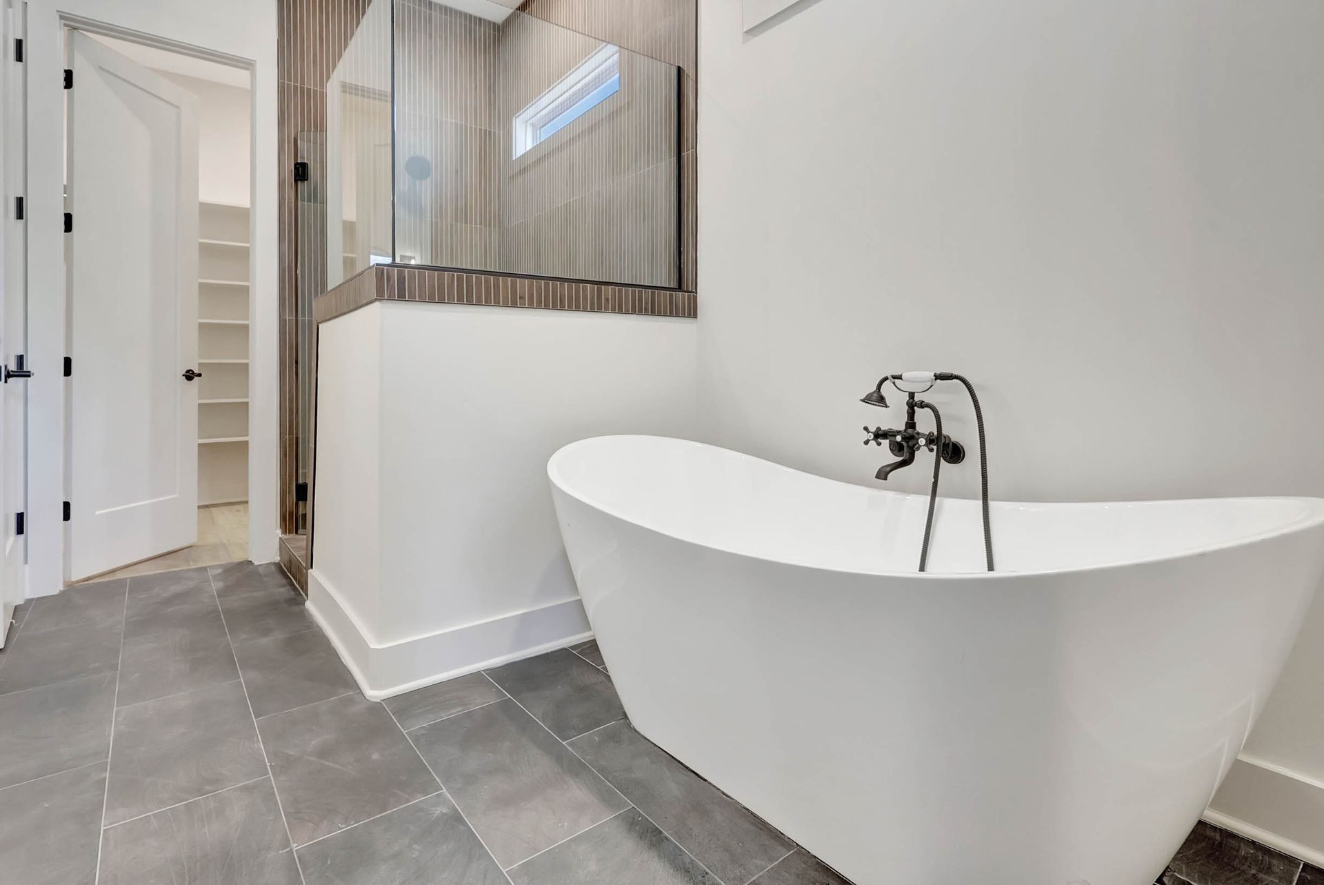 A bathroom with a bathtub and a mirror.
