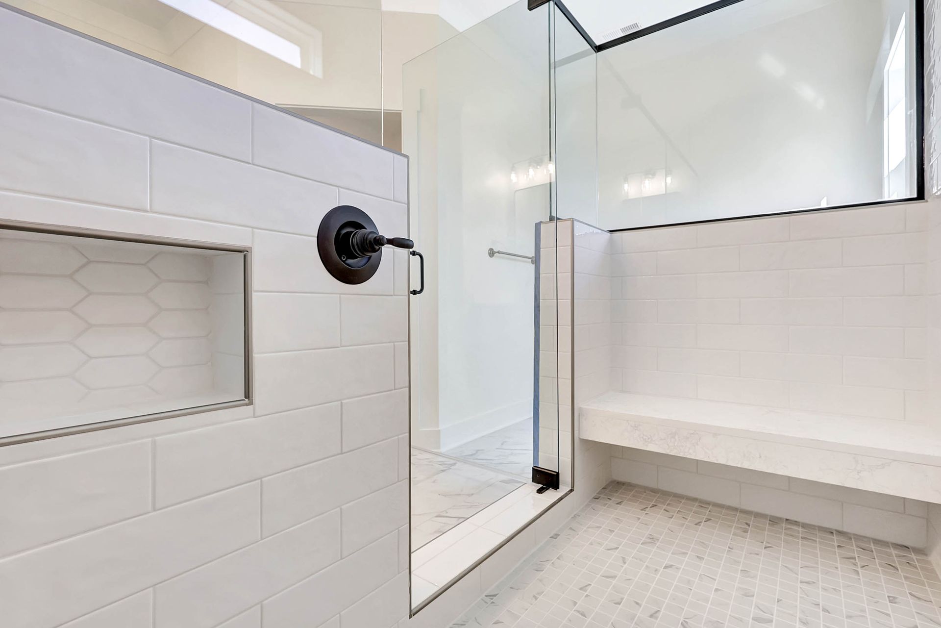 A bathroom with a walk in shower and a bench.