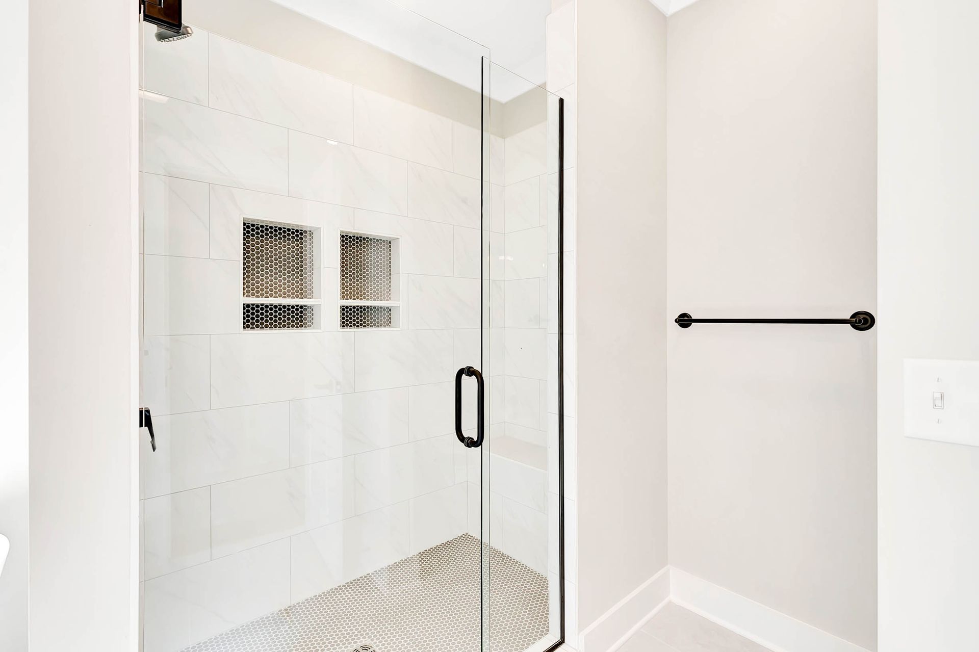 A bathroom with a walk in shower with a glass door.