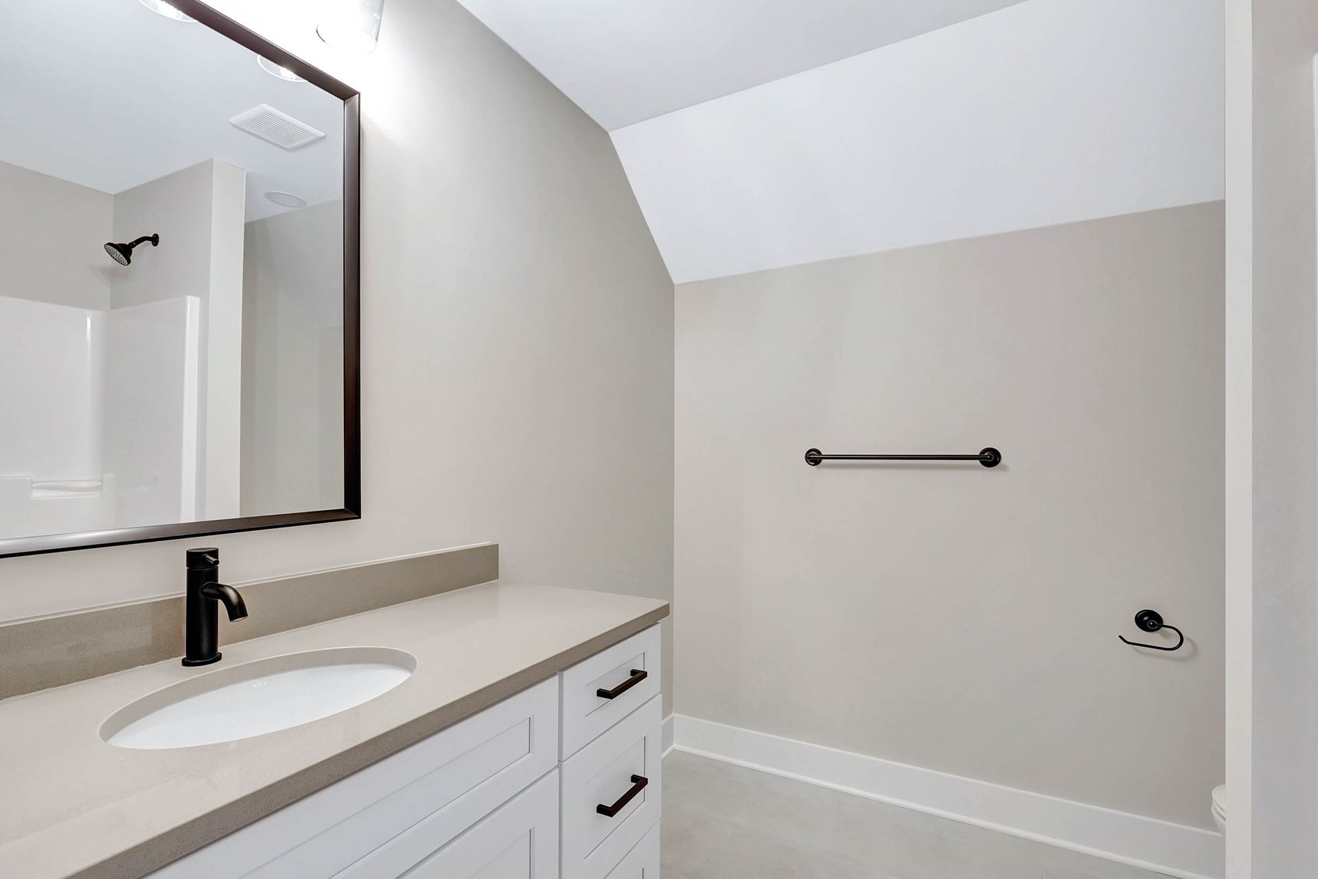 A bathroom with a sink , mirror , and shower.