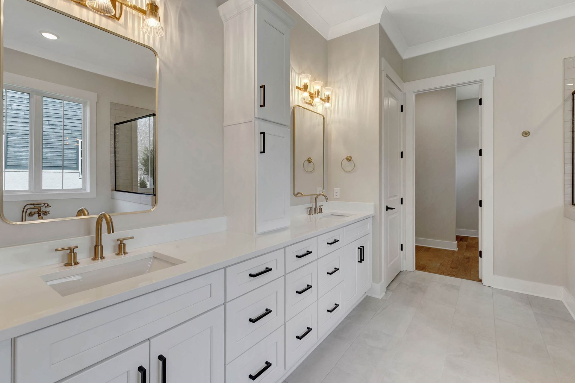 A bathroom with two sinks , two mirrors , and a bathtub.