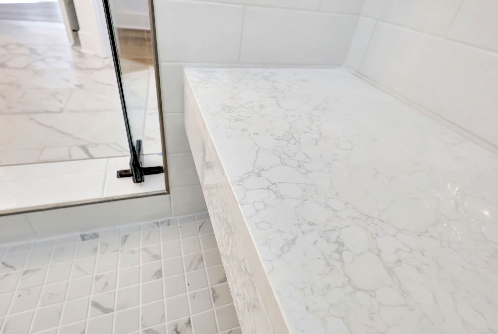A bathroom with a marble bench and a mirror.