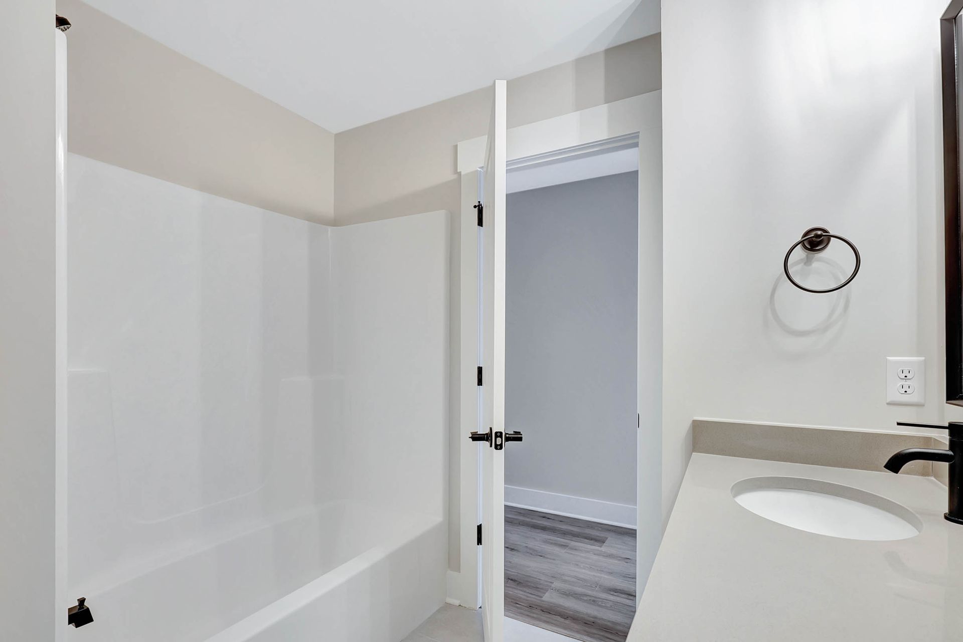 A bathroom with a sink , tub and mirror.