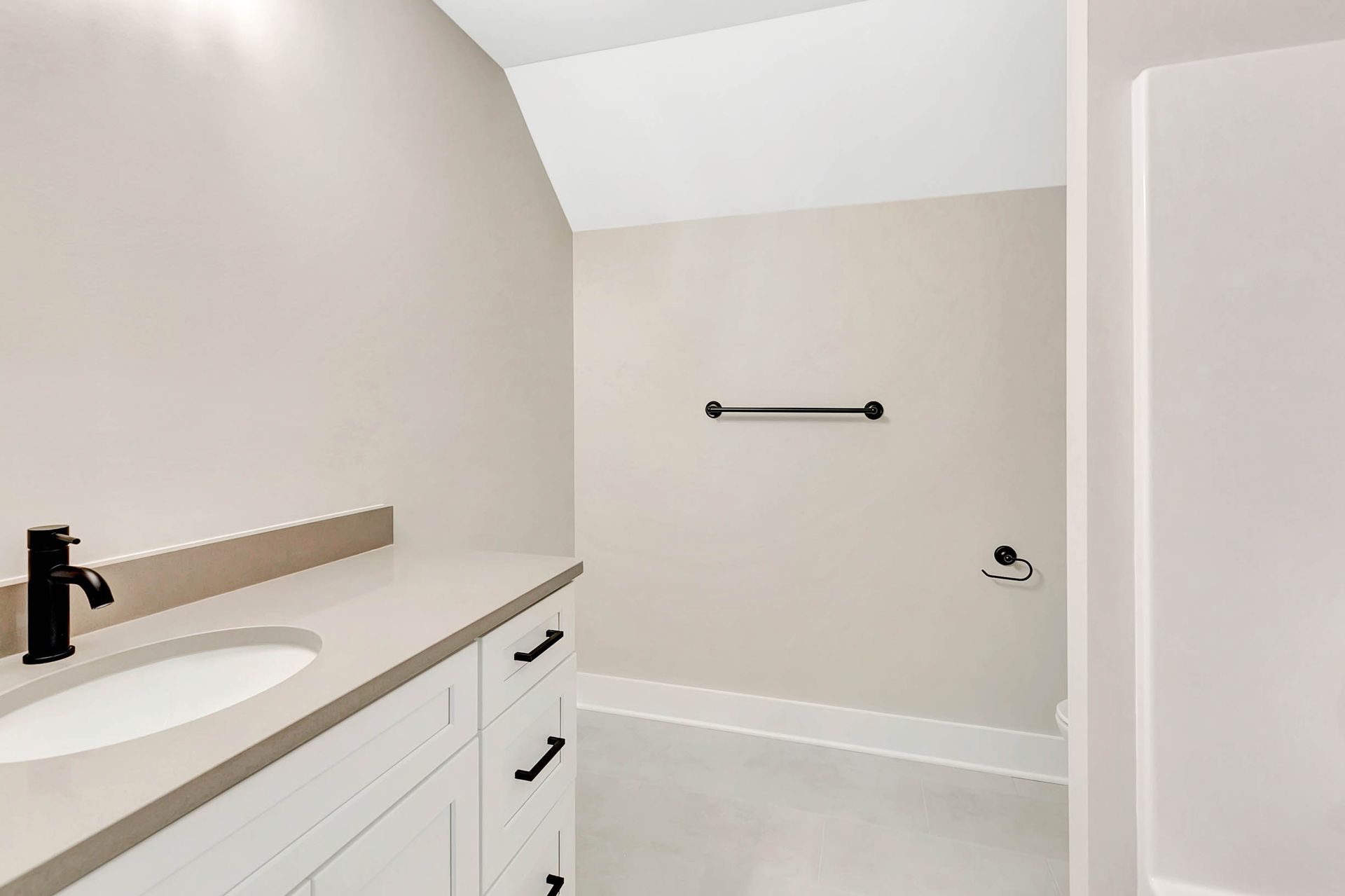 A bathroom with a sink , shower , and towel rack.