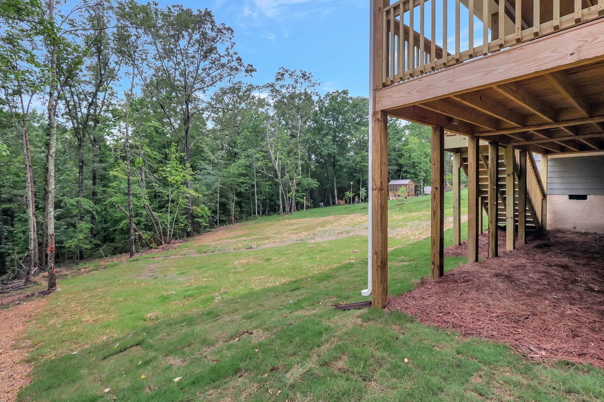 A house with a large deck and a garage underneath it.