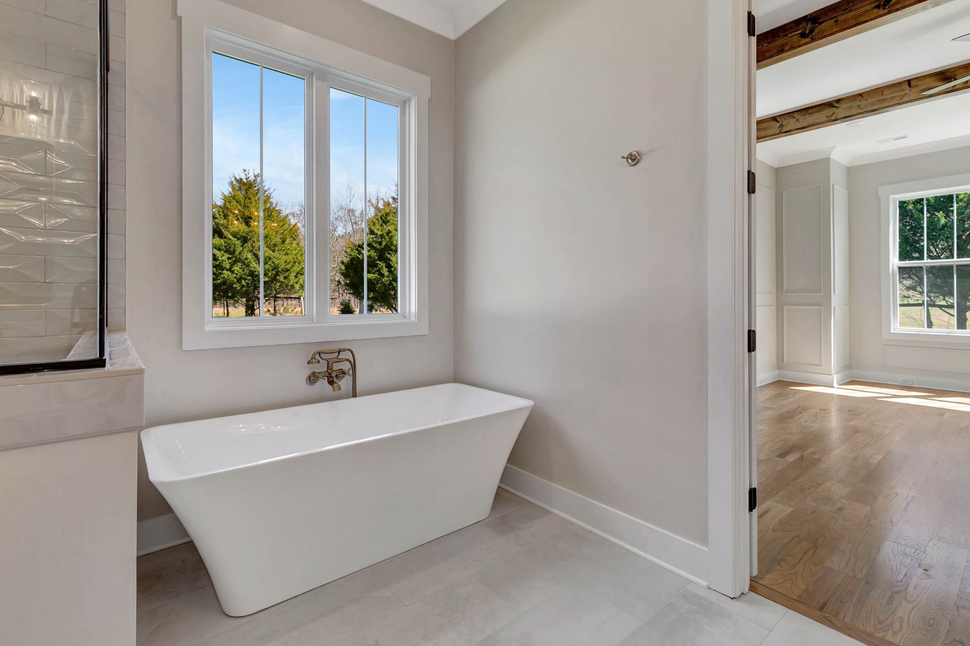 A bathroom with a bathtub and a window.