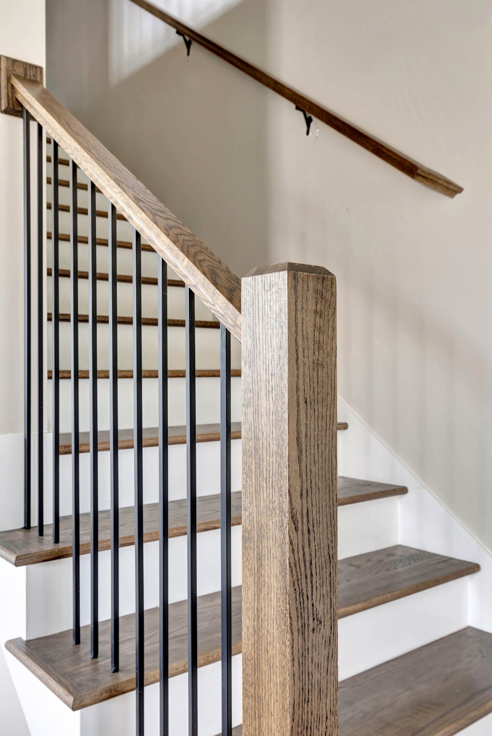 A staircase with a wooden railing and a metal railing