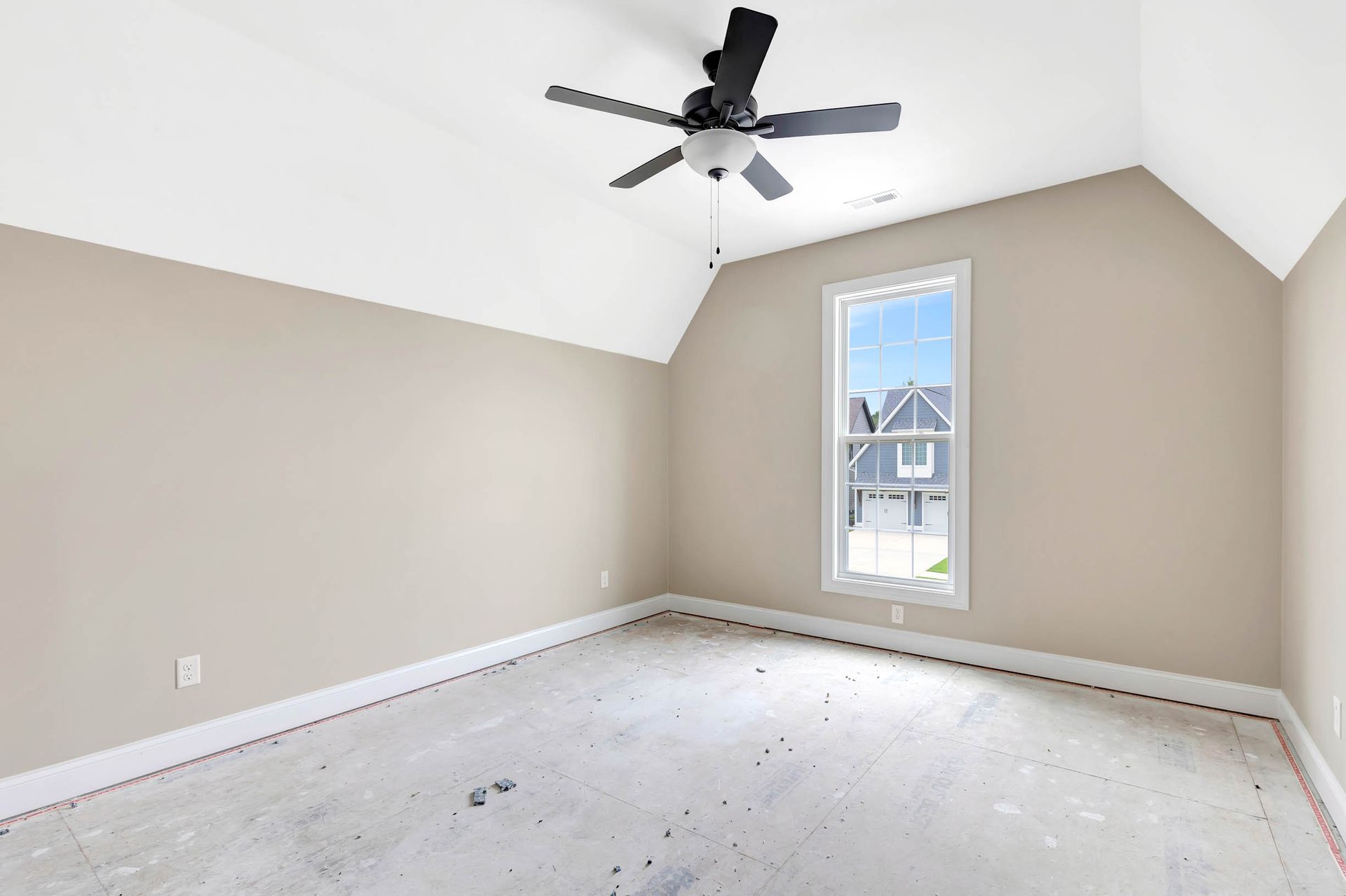 An empty bedroom with a ceiling fan and a window.