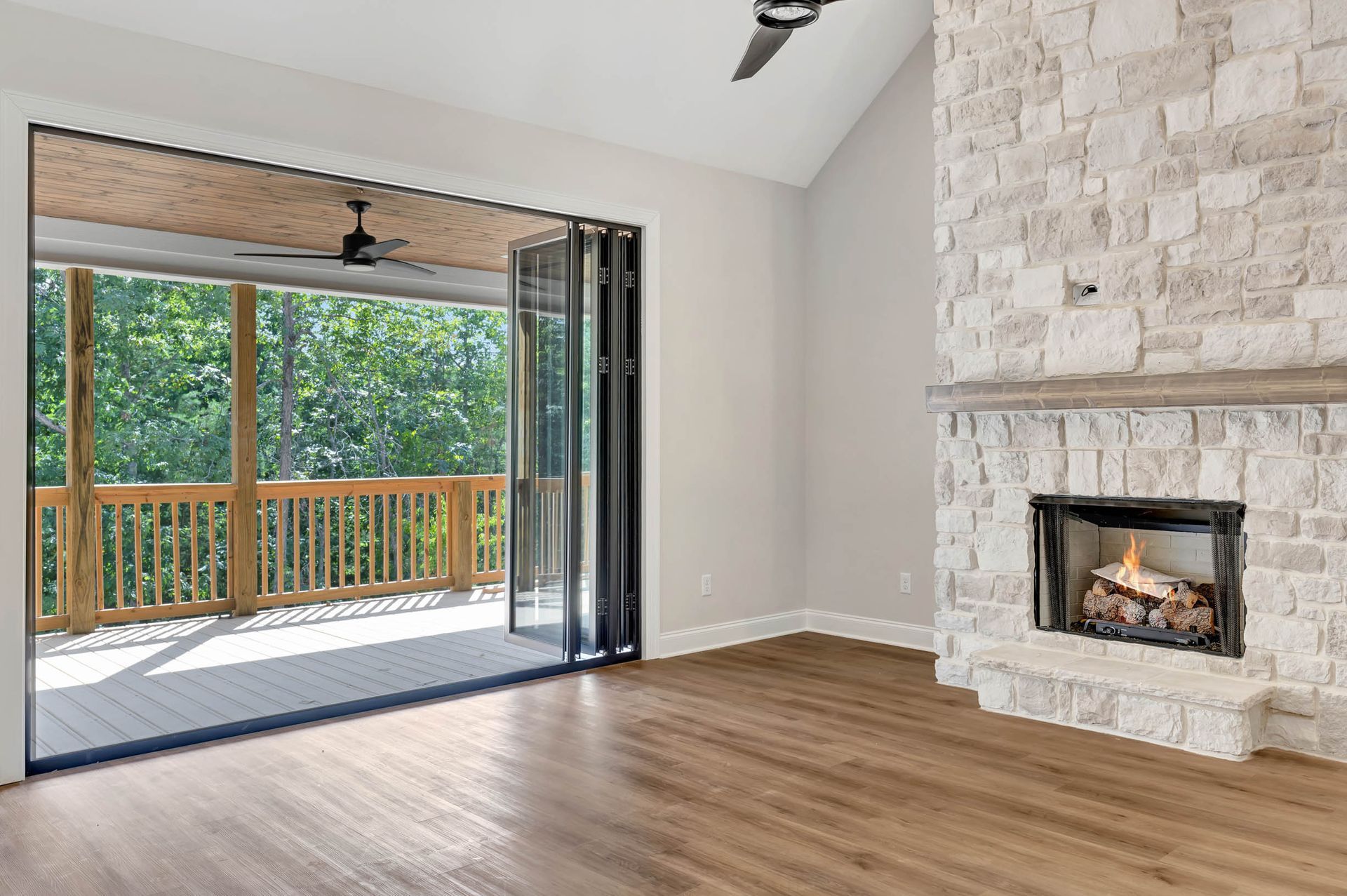 An empty living room with a fireplace and sliding glass doors leading to a deck.