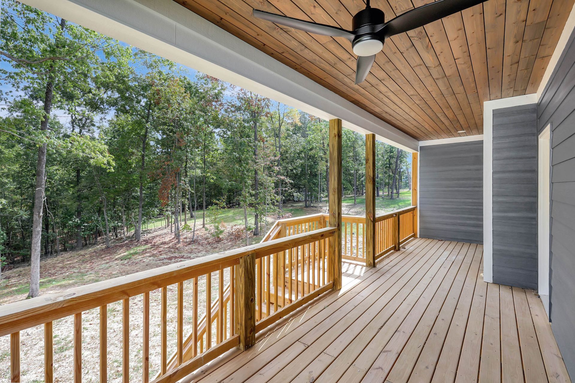 There is a ceiling fan on the porch of a house.