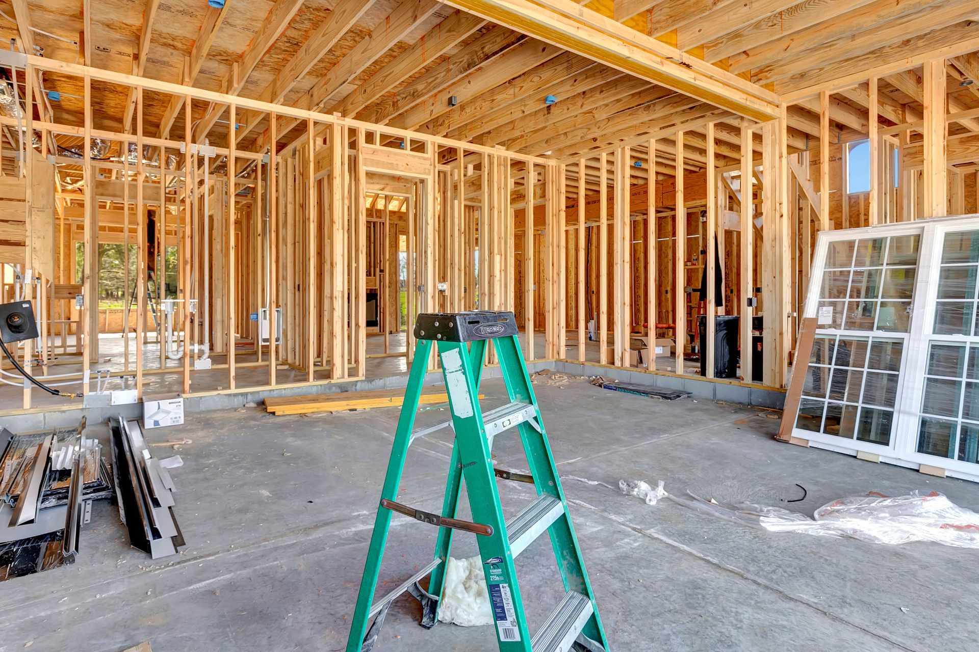 A ladder is sitting in the middle of a house under construction.