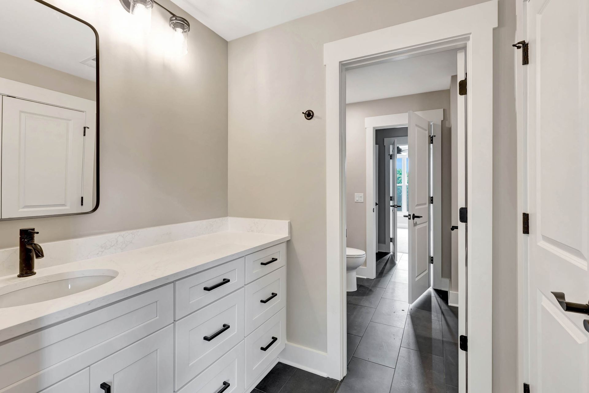 A bathroom with a sink , mirror and drawers.