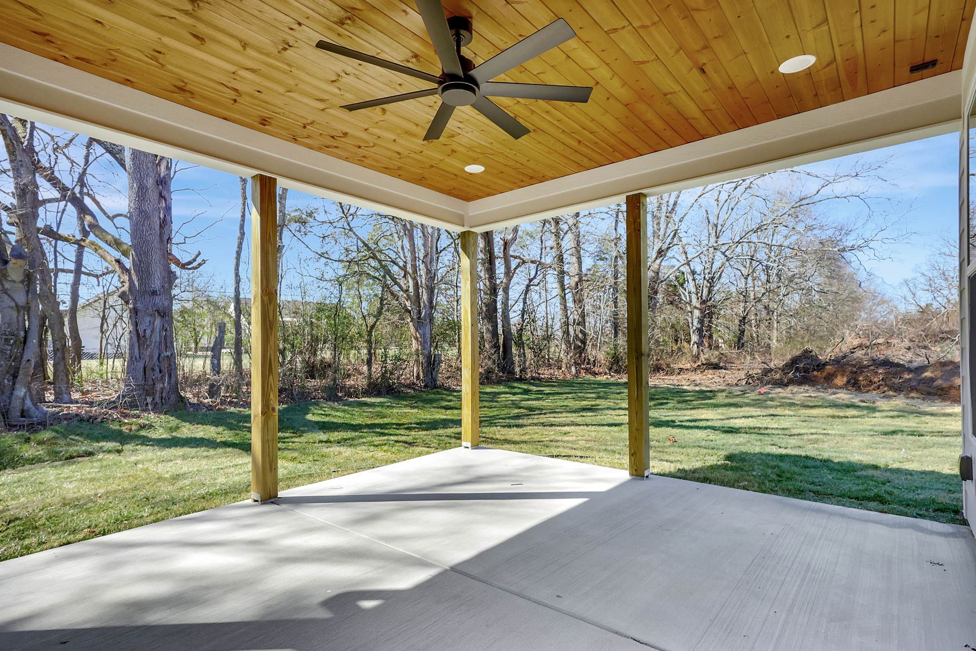 There is a ceiling fan on the porch of a house.