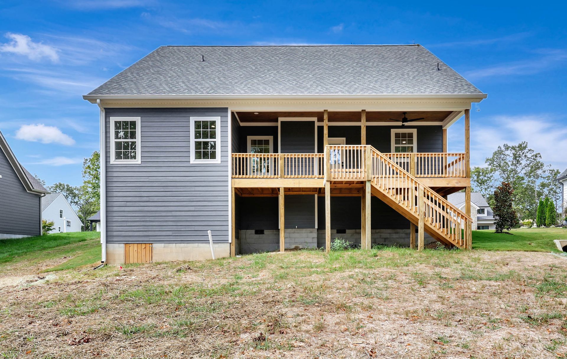 The back of a house with a large deck and stairs.