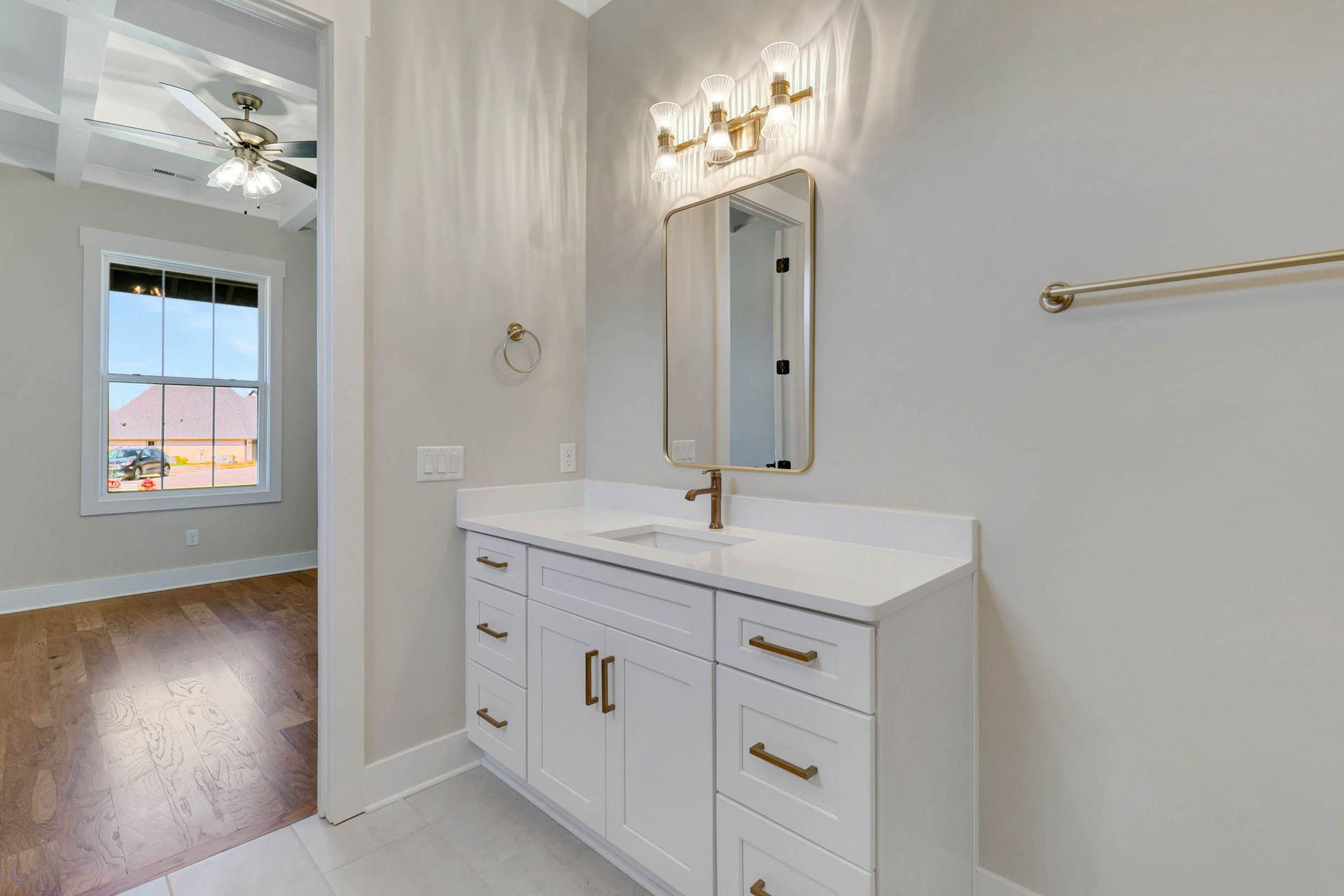 A bathroom with a sink , mirror and drawers.