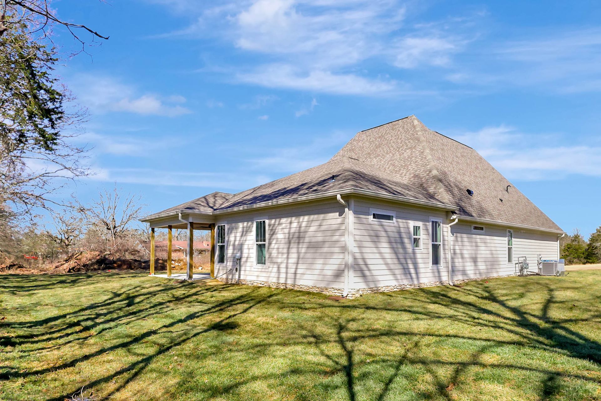 A white house is sitting on top of a lush green field.