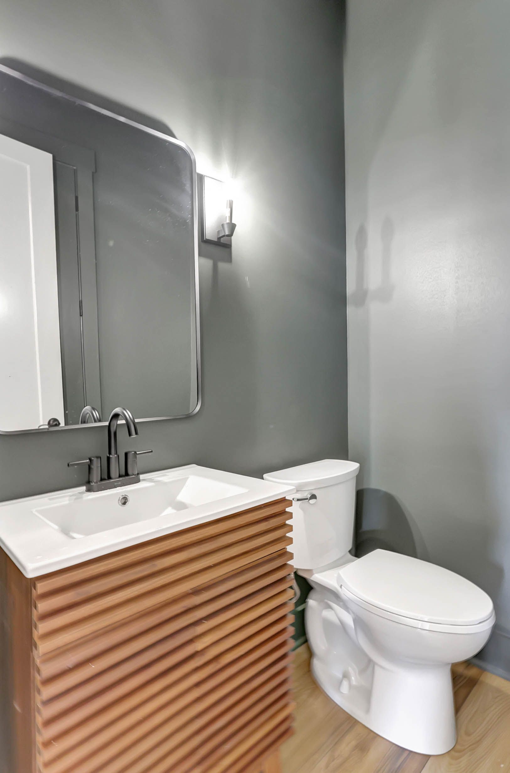 A bathroom with a sink , toilet and mirror.