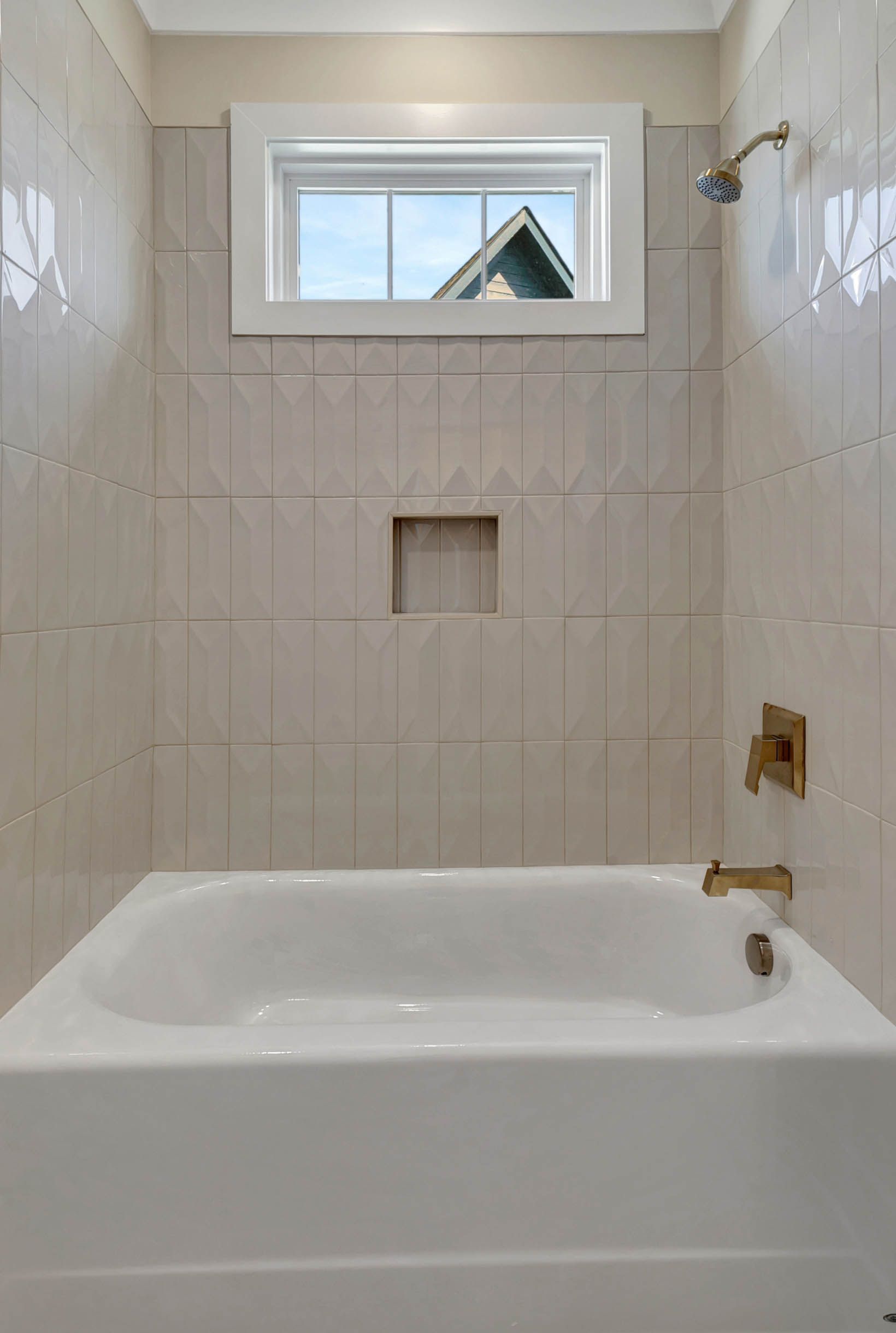 A bathroom with a bathtub and a window.