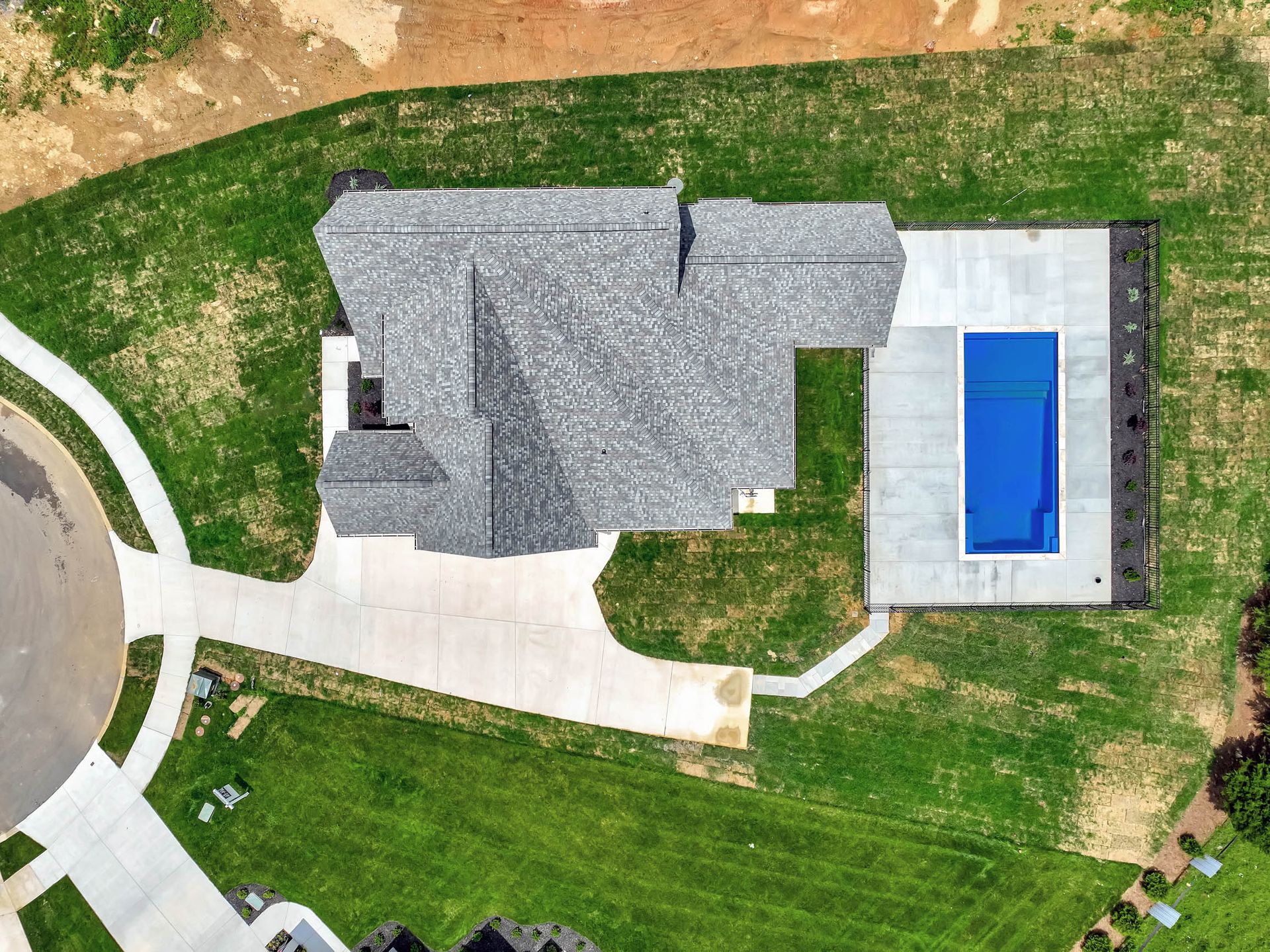 An aerial view of a house with a pool in the backyard.