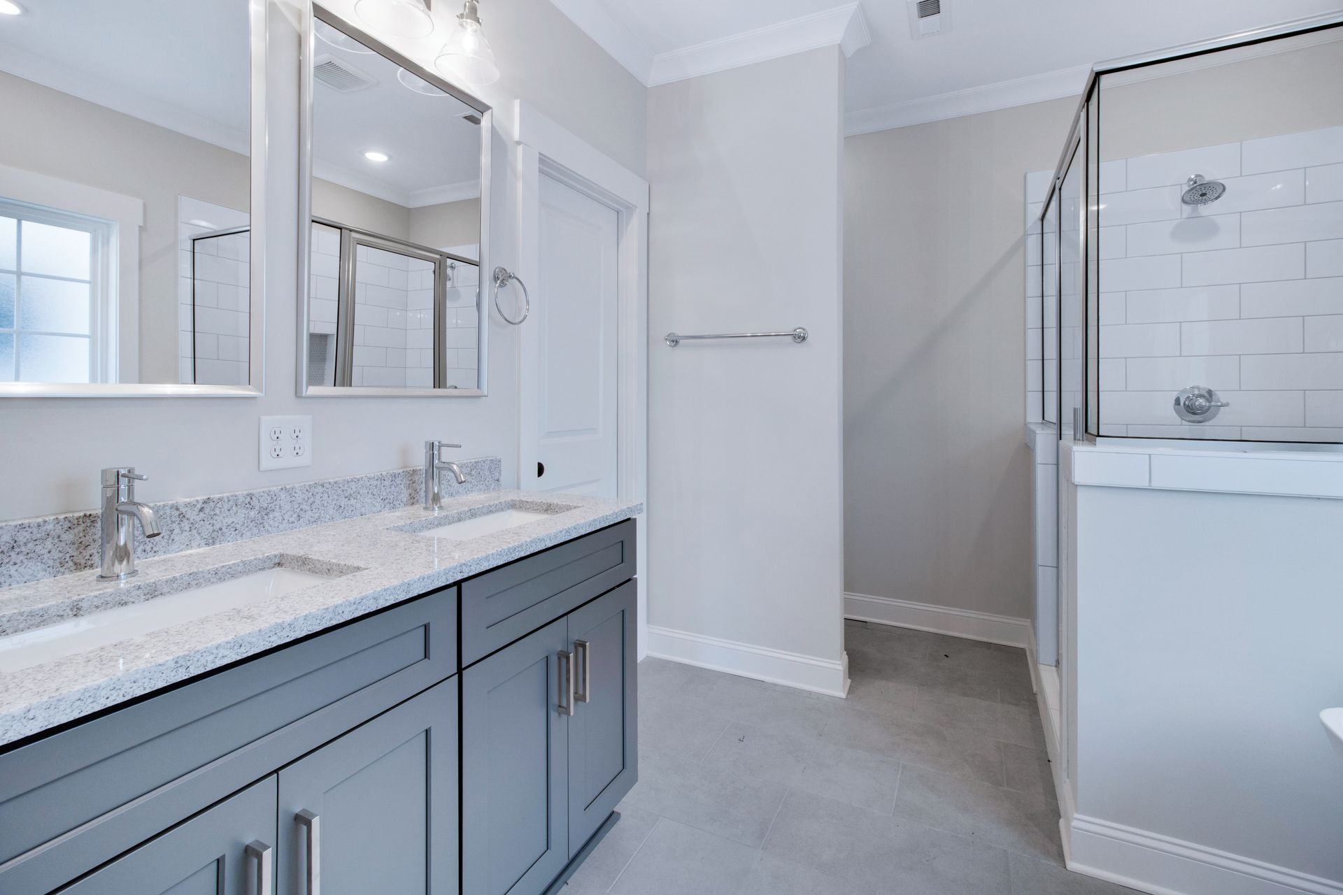 a bathroom with two sinks and a walk in shower .