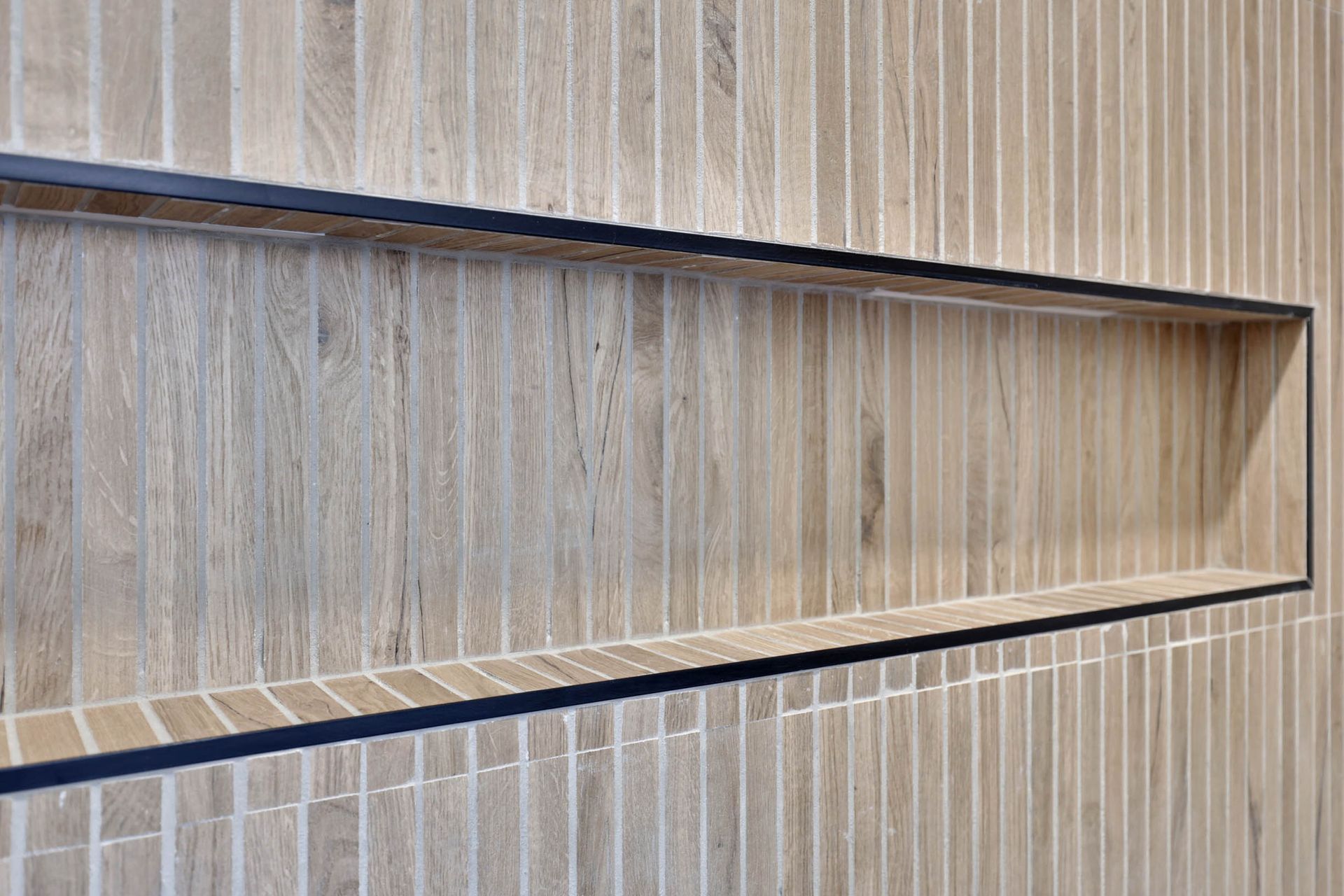 A brick wall with a shelf in the middle of it.