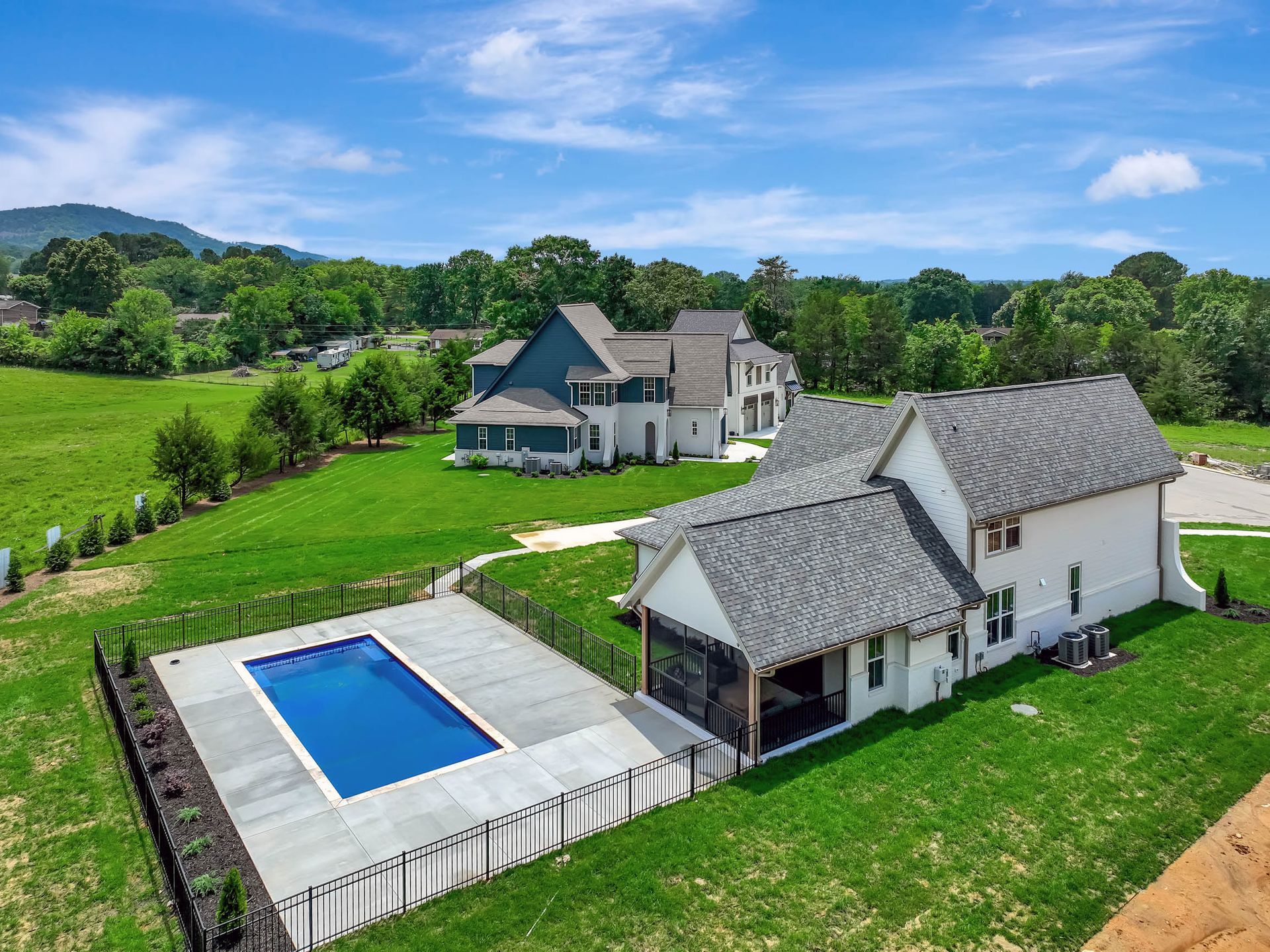 An aerial view of a house with a swimming pool in the backyard.
