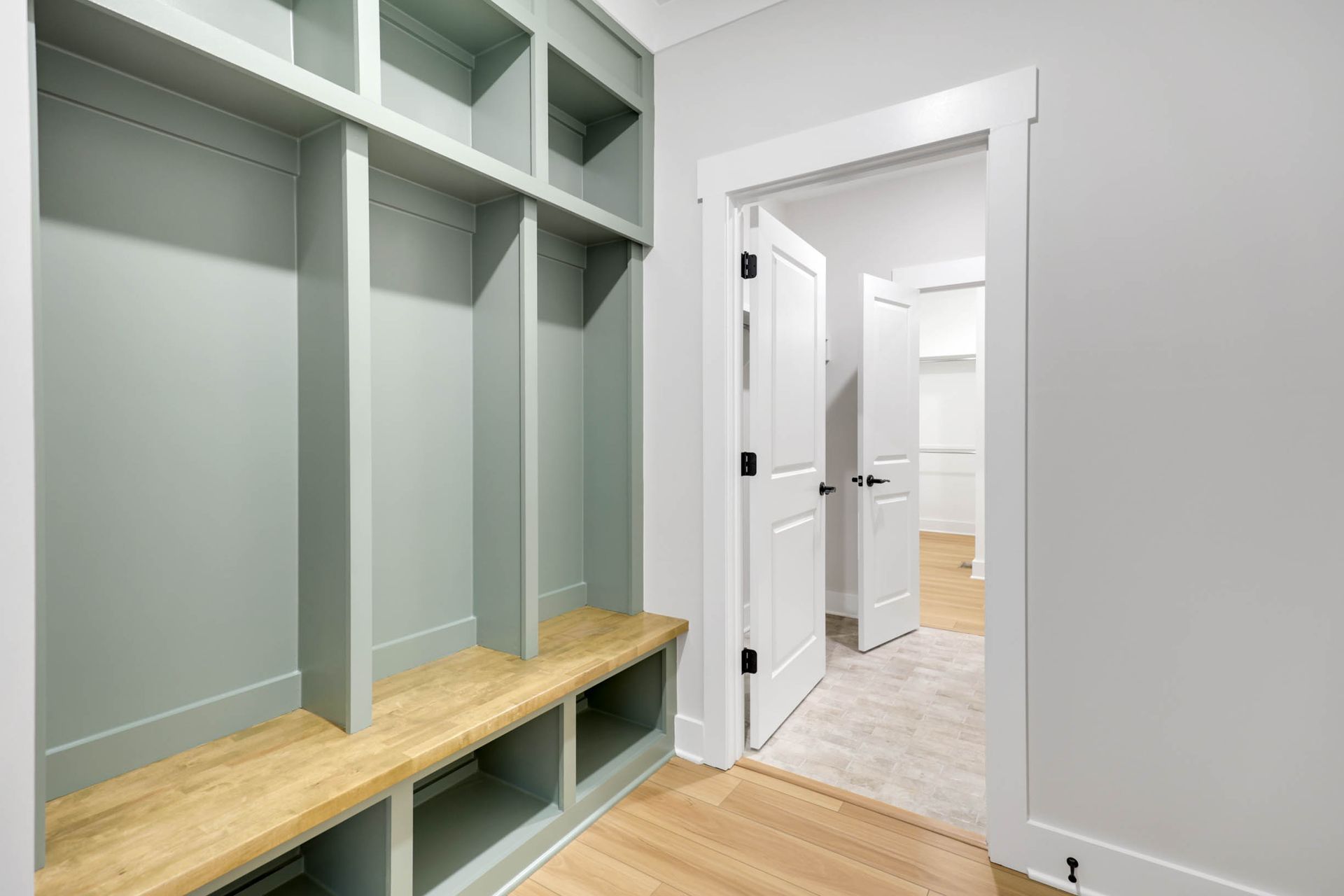 A mud room with a bench and shelves in a house.