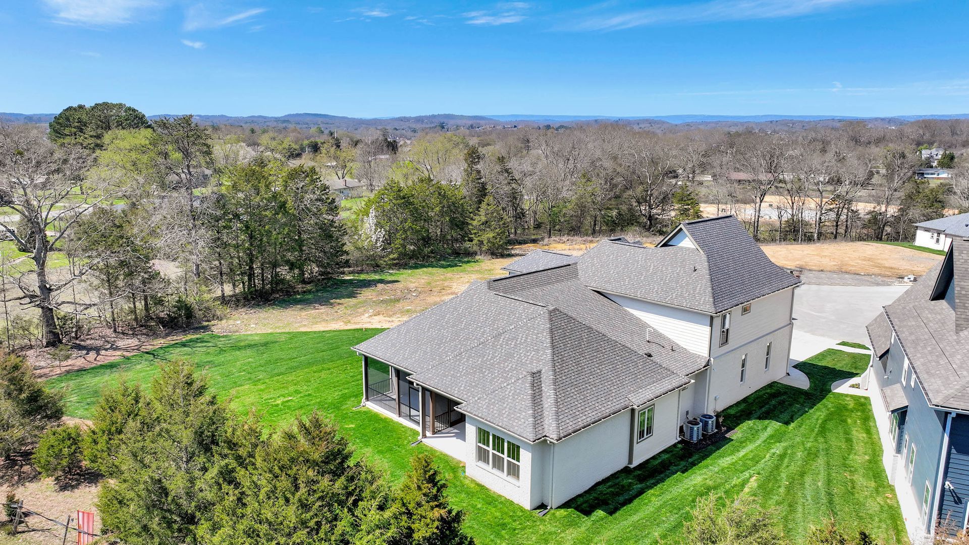 An aerial view of a large house with a large lawn in front of it.