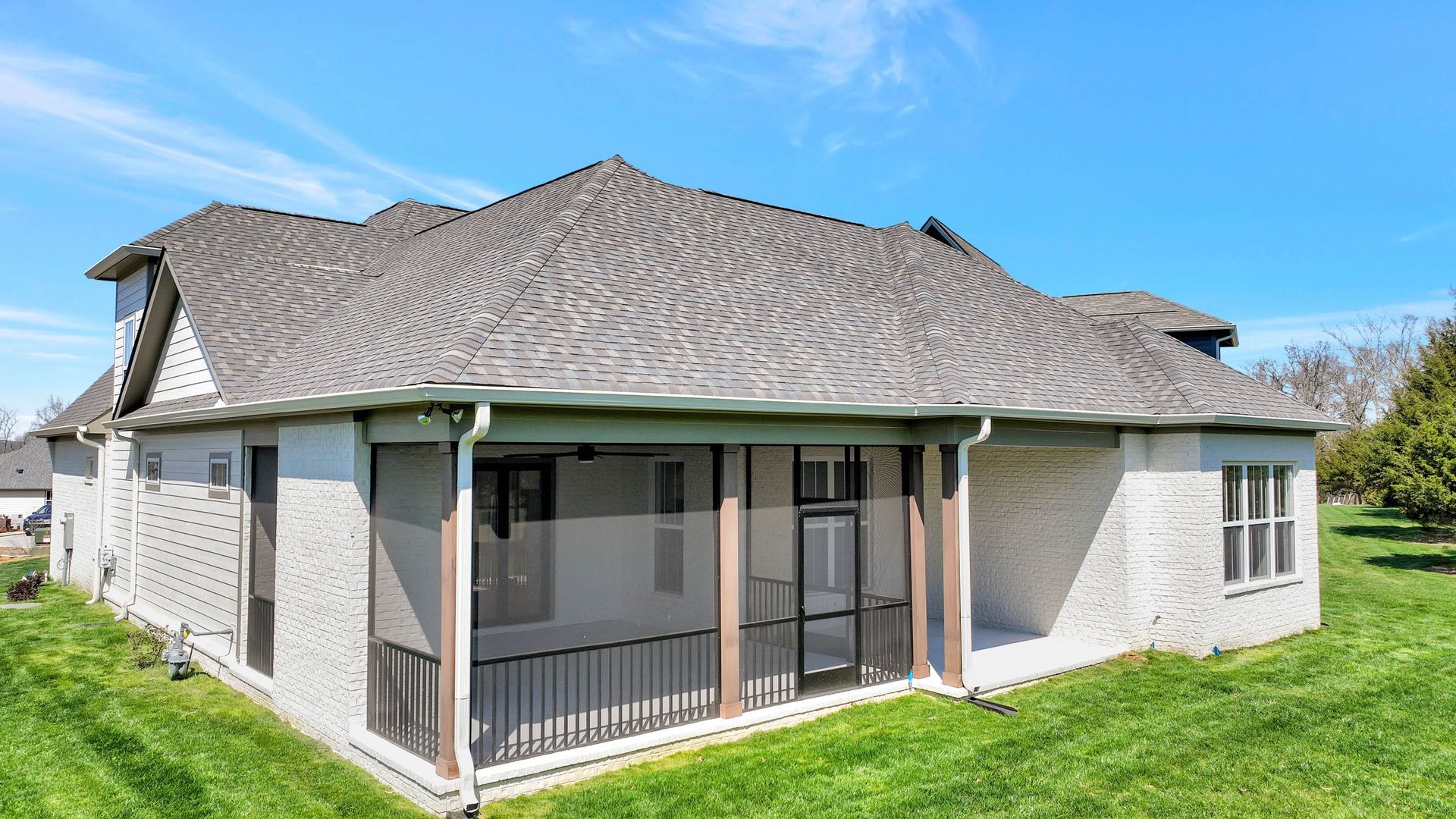 The back of a house with a screened in porch.